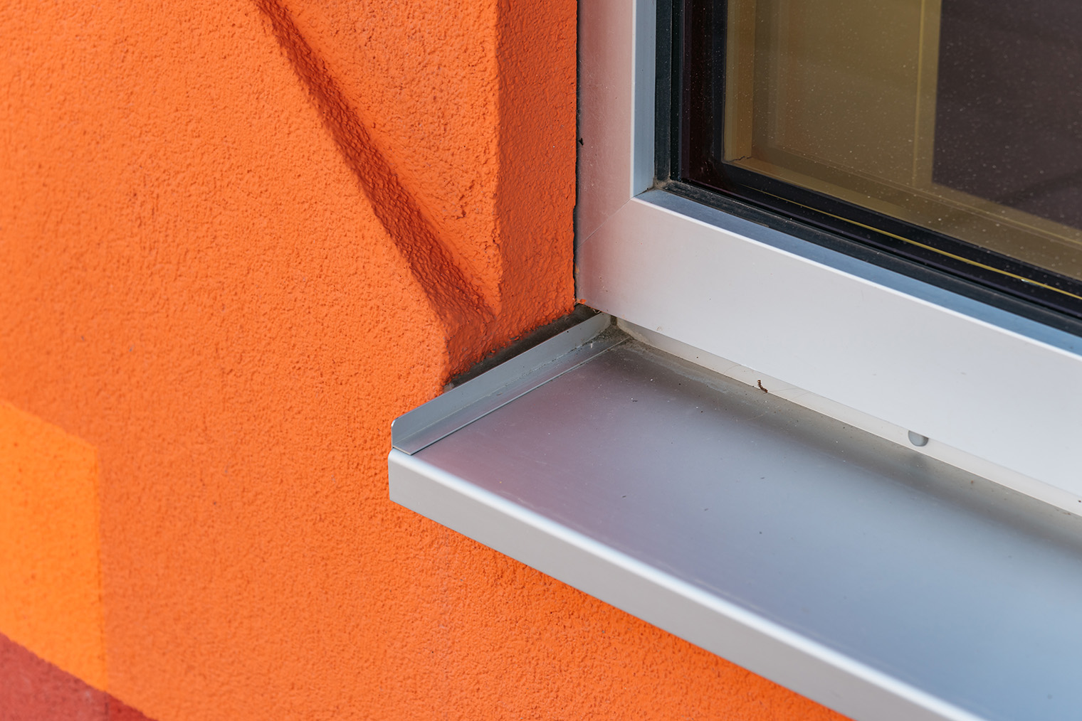 Снаружи откосы зачастую отделаны так же, как и фасад. В данном случае — оштукатурены. Под окном устанавливают металлическую водоотливную планку. Фотография: JJFarq / Shutterstock