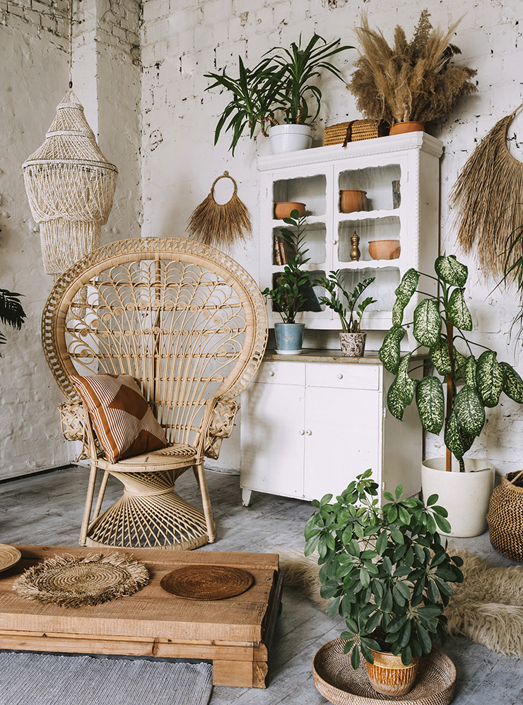 Плетеный абажур, кресло из ротанга, живые цветы и керамика — все это типичный для бохо декор. Фотография: brizmaker / Shutterstock