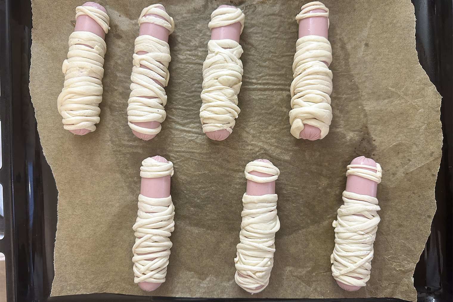 Заворачивайте сосиски в тесто, делая из него шапочку и туловище