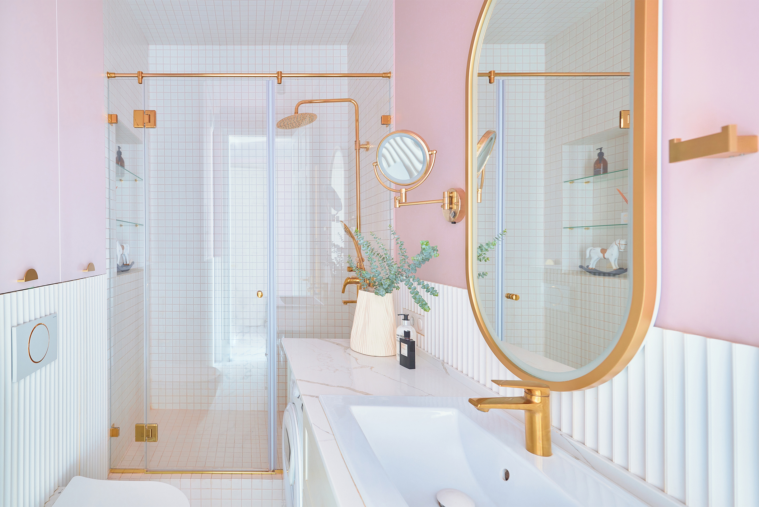 В ванной белый и розовый слабо контрастируют друг с другом и поэтому сливаются в один светлый фон, позволяя золотым деталям проявиться сильнее