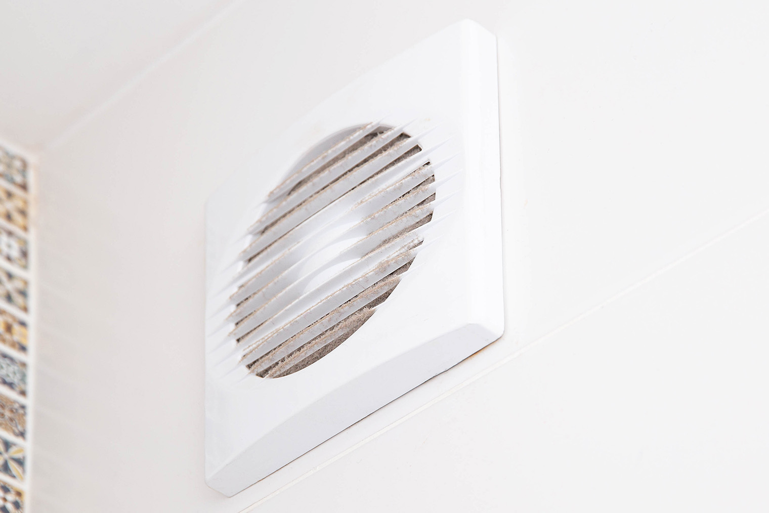 Внешне вытяжной вентилятор выглядит как обычная пластиковая вентрешетка. Но под ней вентилятор, который запитан от выключателя и запускается при включении света. Фотография: Henadzi Pechan / iStock