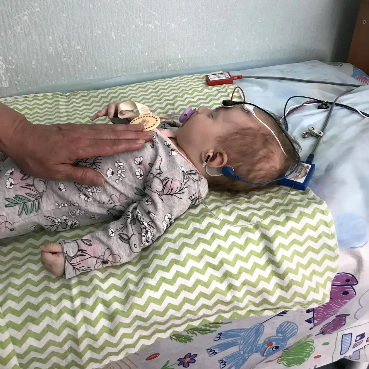 Здесь Алисе около четырех месяцев. Мы на приеме у сурдолога, который проверяет ей слух методом КСВП