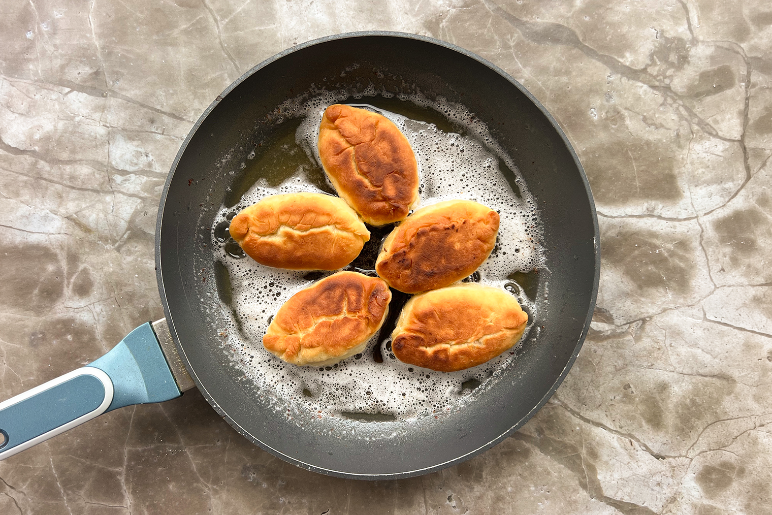 Все масло сразу добавлять не обязательно: ориентируйтесь на размер вашей сковороды. Главное, чтобы жир покрывал пирожки примерно на половину