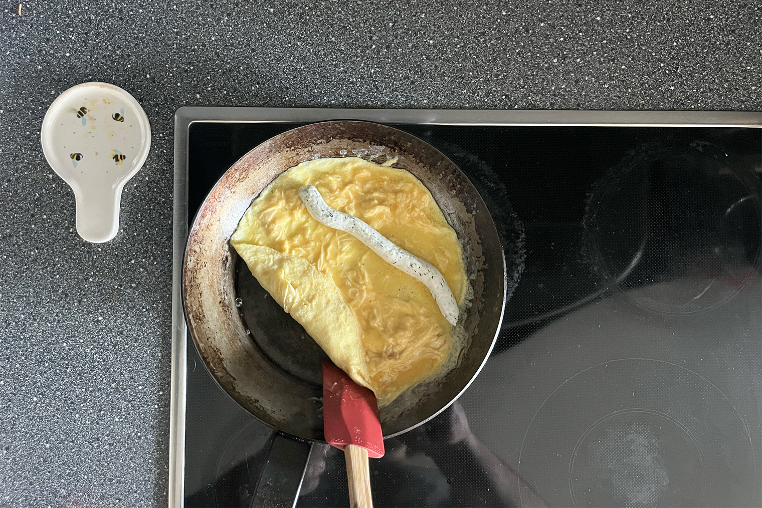 Я не очень удачно разместил сырную начинку: лучше выдавливать ее ближе к ручке сковороды. Так она будет в самом центре омлета
