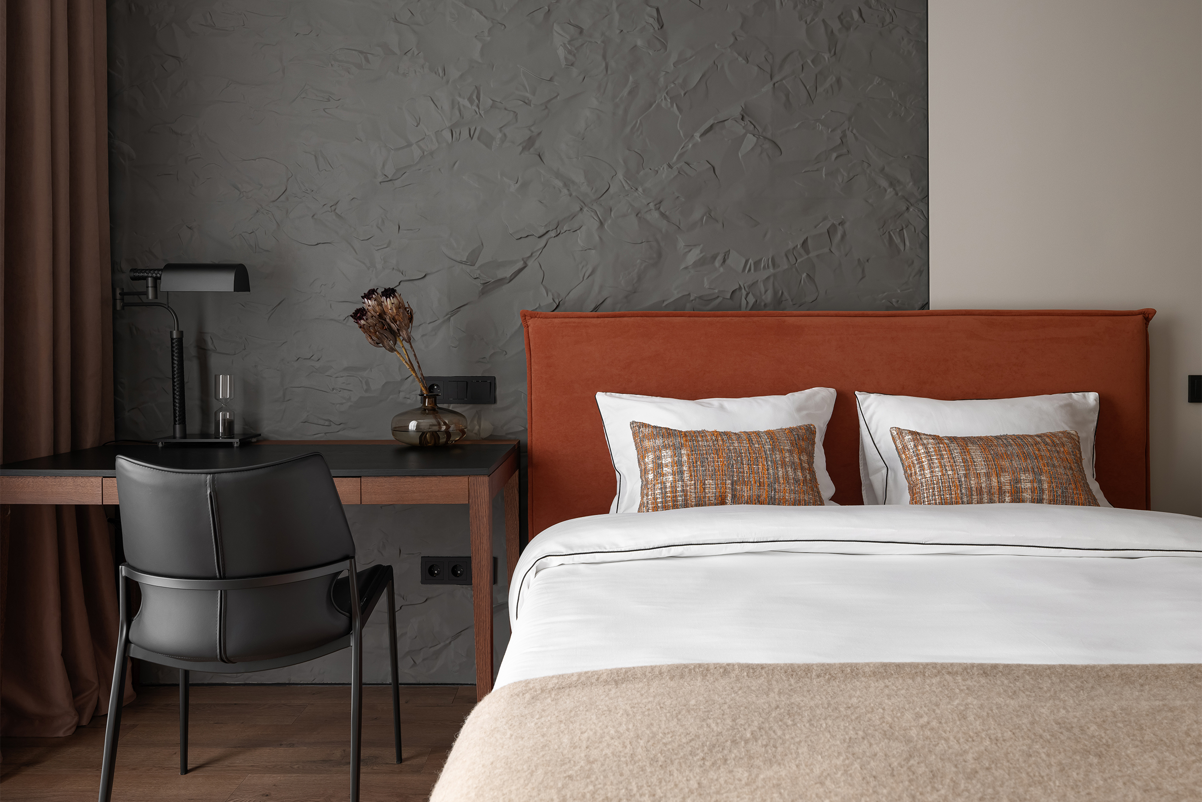 Обратите внимание на постельное белье и плед: белье специально гладкое и нейтрально-белое, а плед — более мягкий и фактурный. Это сделано, чтобы уравновесить контрасты в интерьере спальни