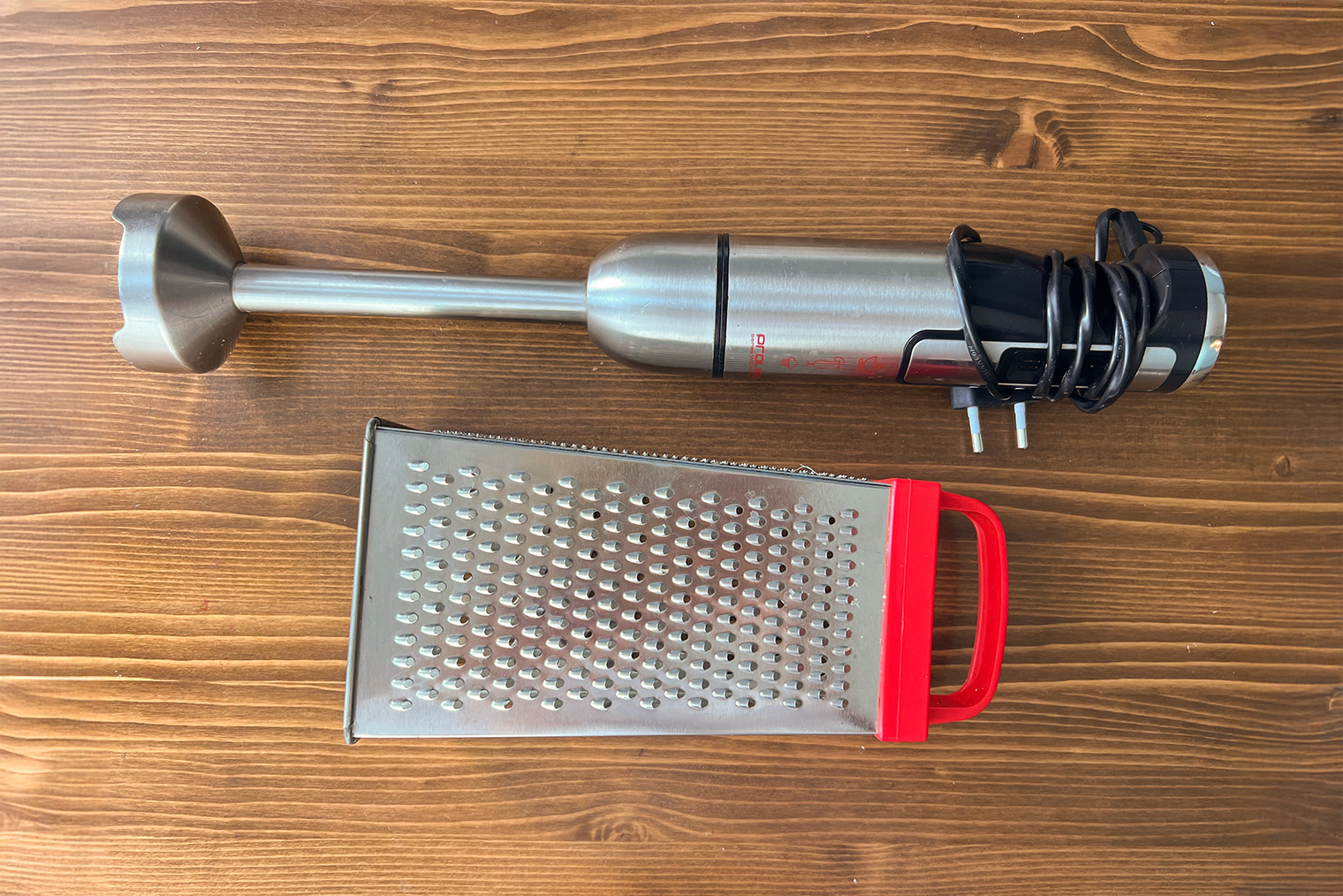 Из инвентаря понадобится погружной блендер, мелкая терка, сковорода и большая кастрюля — нужно, чтобы в нее целиком поместилась курица. Если у вас посуда меньше, разделайте птицу