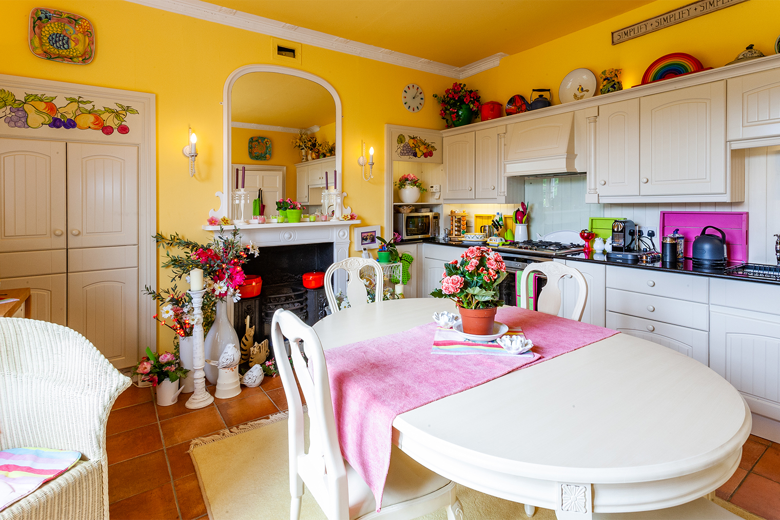 Множество ярких элементов утомляет: желтые стены, цветы, салатовые и розовые аксессуары у зеркала, на столешнице и дорожка на столе. Это перегружает внимание. Фотография: Ian Luck / Shutterstock