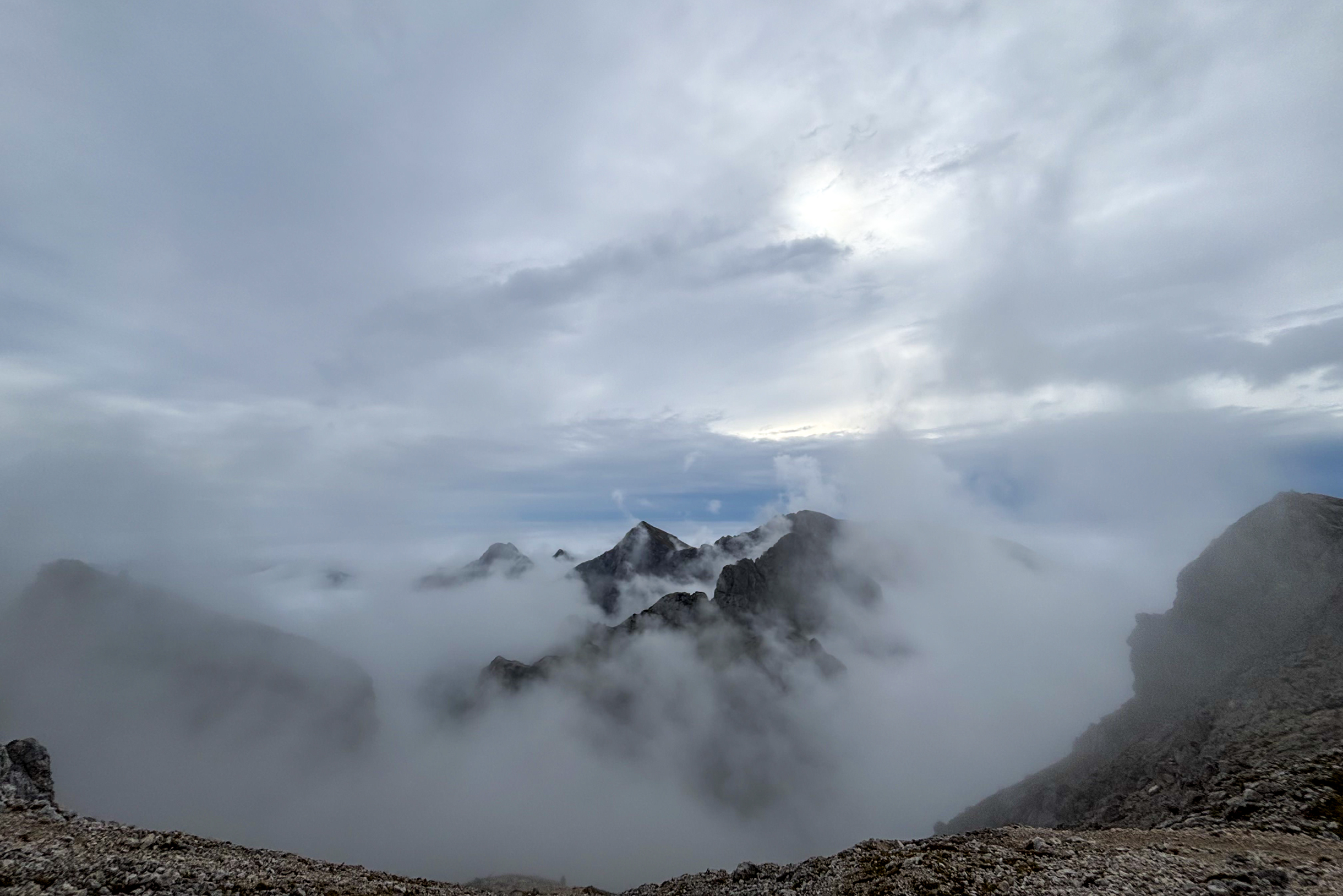 На следующий день мы поднялись на вершину Триглава. За несколько дней до этого там прошел ураган со снегом, видимо, поэтому людей на маршруте не было. Встретили только одну пару в середине пути, но наверх они не пошли. Когда поднимались, все заволокло туманом, но в какой-то момент его сдуло и мы оказались выше облаков