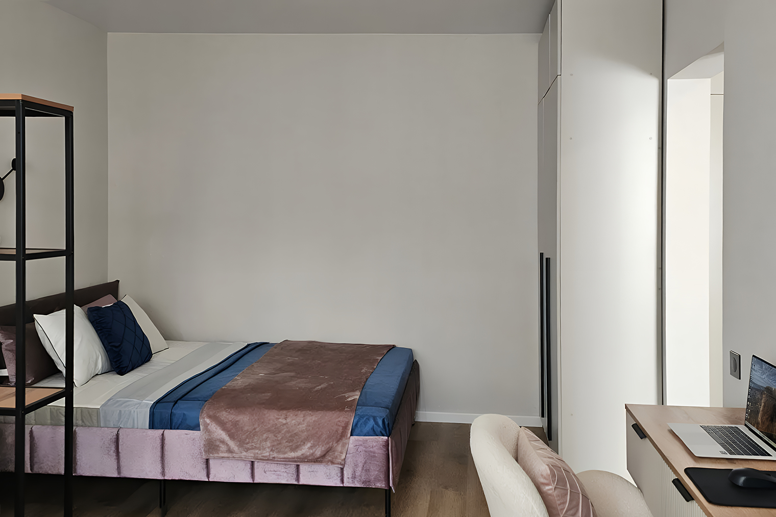 Кровать поставили вплотную к стене, а рядом повесили тумбу с зеркалом. Напротив кровати уместился белый шкаф. На фото его практически не видно — так и задумано