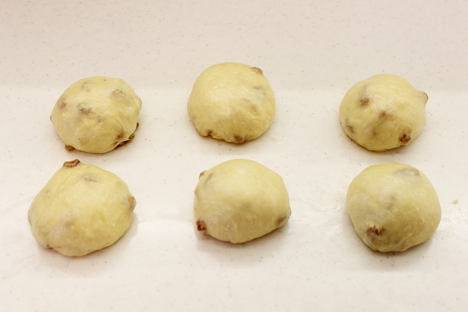 Старайтесь скатать шарики таким образом, чтобы на поверхности не торчали изюминки: так они не сгорят при выпечке