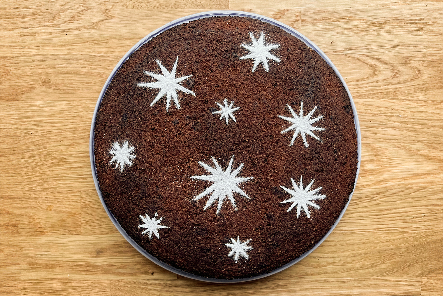 Готовый пирог с горьким шоколадом и узором из сахарной пудры