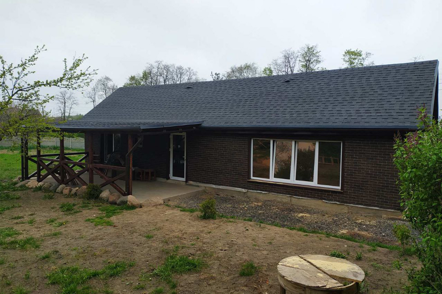 Таким дом получился снаружи. Гибкую черепицу выбрали, чтобы не слышать, как стучит дождь по крыше