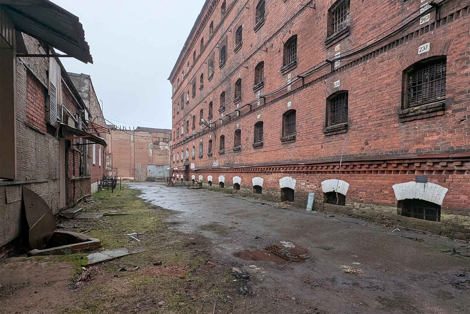 Над окнами белой краской указаны номера камер