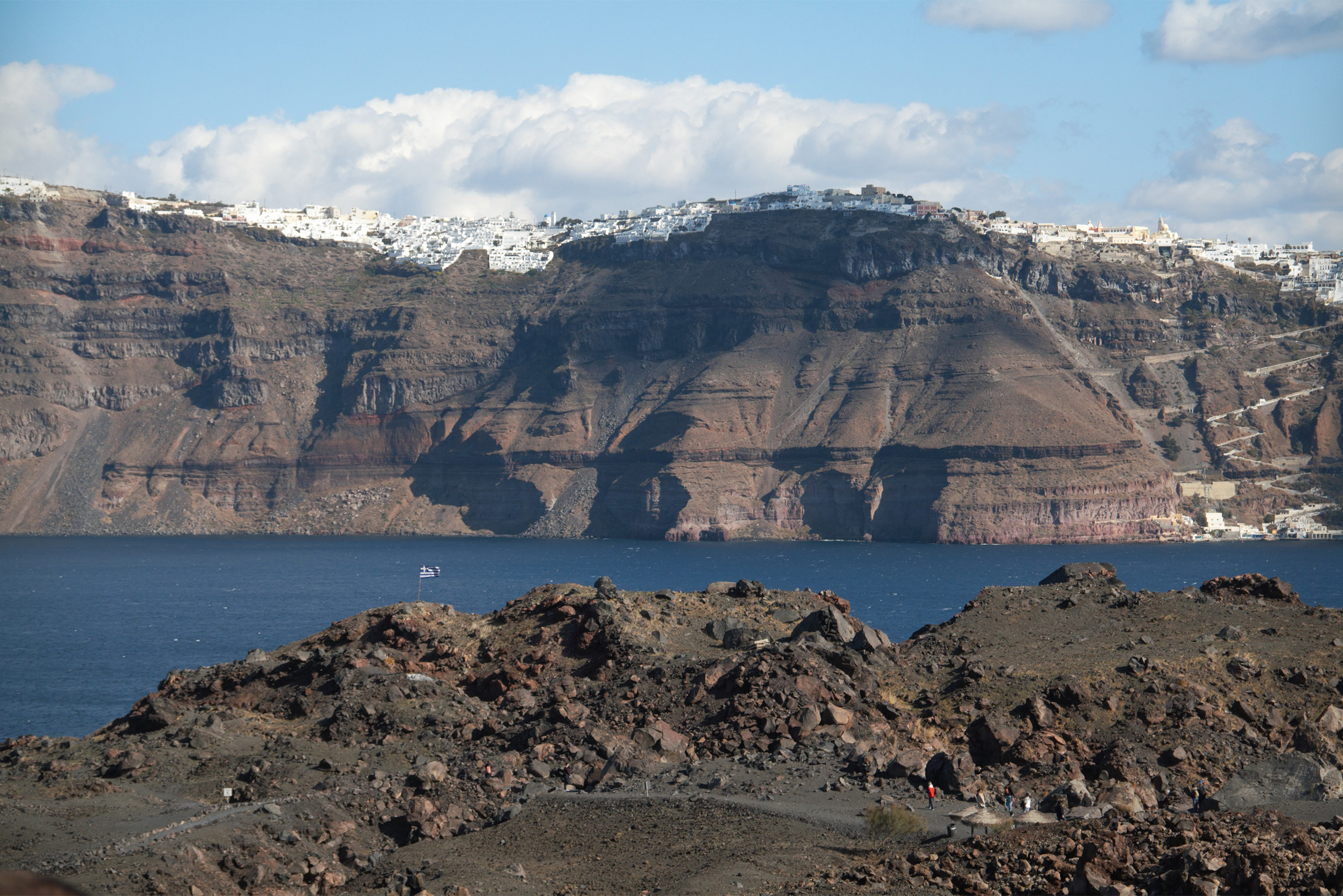 Вид с Неа-Камени на Тиру, она же Фира. Это самый крупный город Санторини и его столица. На снимке она на самом верху кальдерыКальдера — обширная котловина вулканического происхождения, выглядит как снег