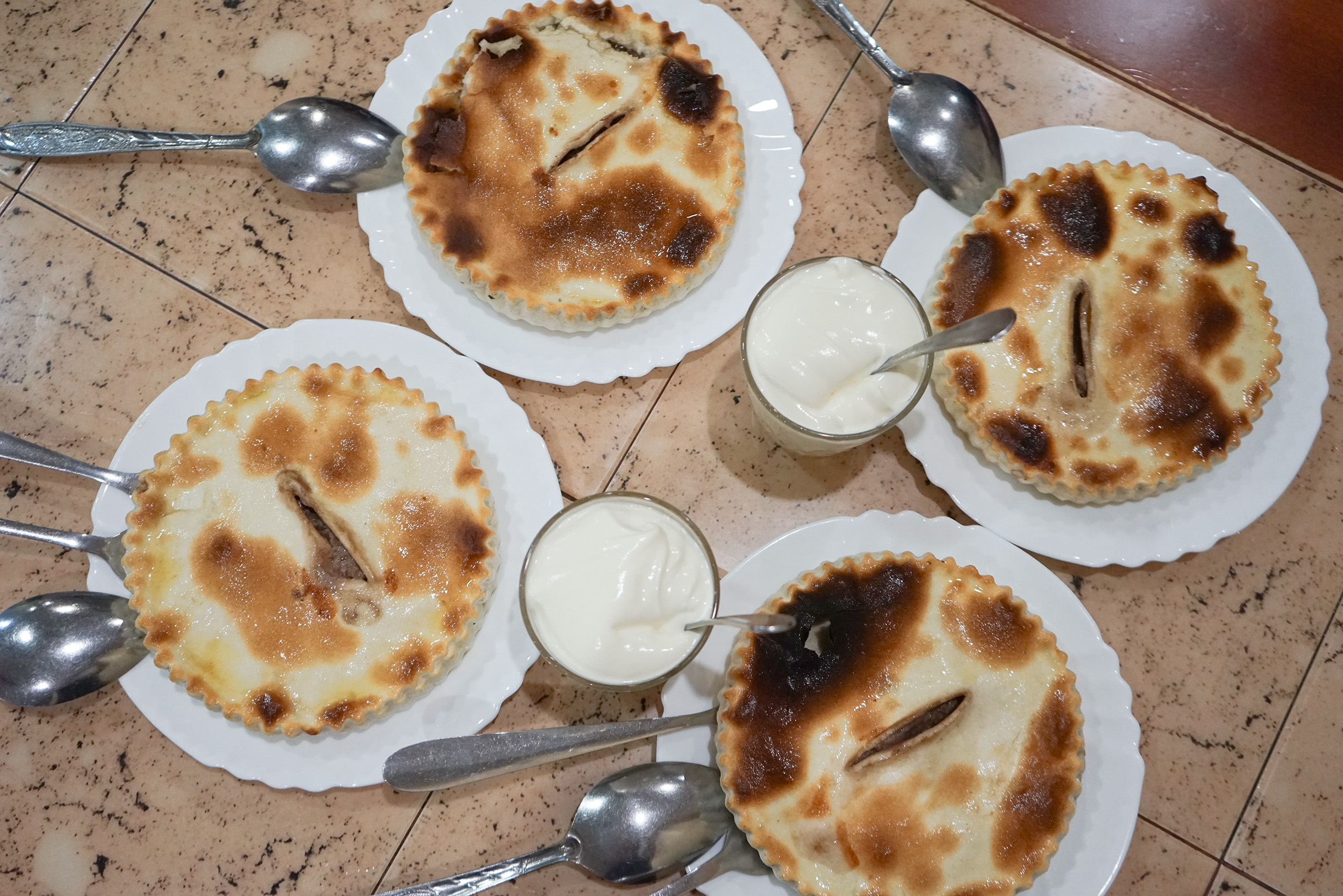 Как и в любом другом регионе на Кавказе, местная кухня восхитительна. Секрет прост: все свежее. Меня поразила разновидность осетинских пирогов, про которую я не знала, — фыдчин, или фыдджын. Если обычные осетинские пироги тонкие и плоские, то фыдджын — с высокими бортиками, как будто тарелочка из теста. По форме он похож на киш — только сверху не открытая начинка, а корочка с небольшим разрезом в центре. Ее нужно поддеть двумя вилками. Внутри — большой кусок мясного фарша, который готовился в собственном соку. Его едят, отламывая по кусочку, и макают вместе с тестом в сок. К фыдджыну подают целый стакан соуса цахтон — это смесь сметаны, чеснока и перца. В моем личном рейтинге сочетаний «мясо плюс тесто» фыдджын занял первое место, обойдя пельмени, буузы, манты и хинкали