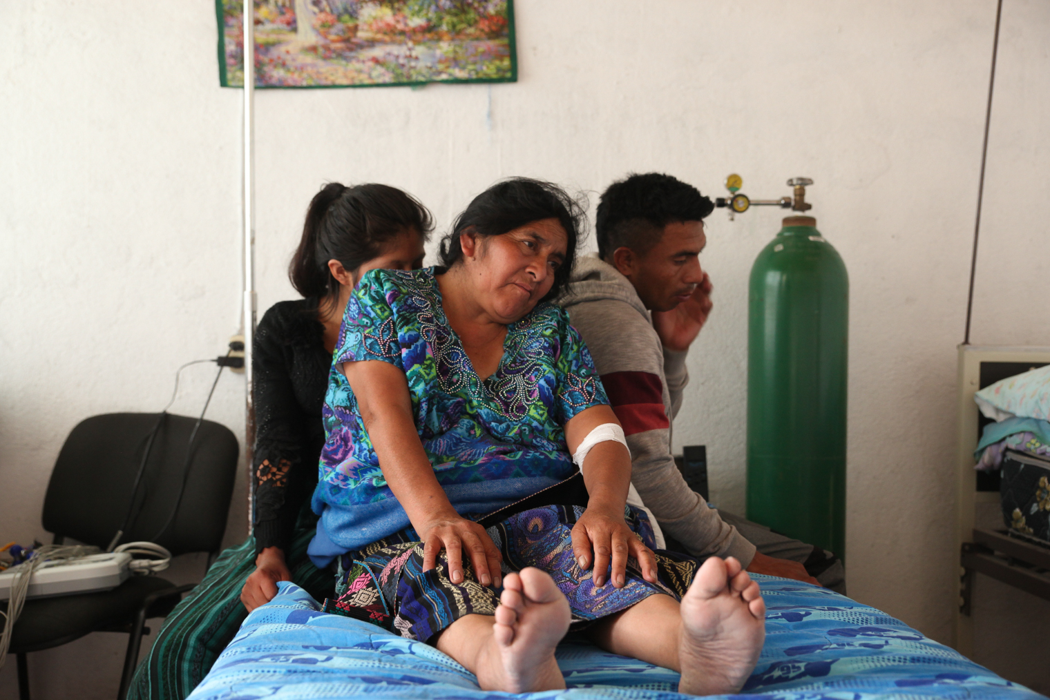 Некоторые фотографии я сделала, когда снимать казалось неуместным. Эту женщину привезли в клинику с сердечным приступом, ее на пару мгновений приподняли дети — и я поймала кадр