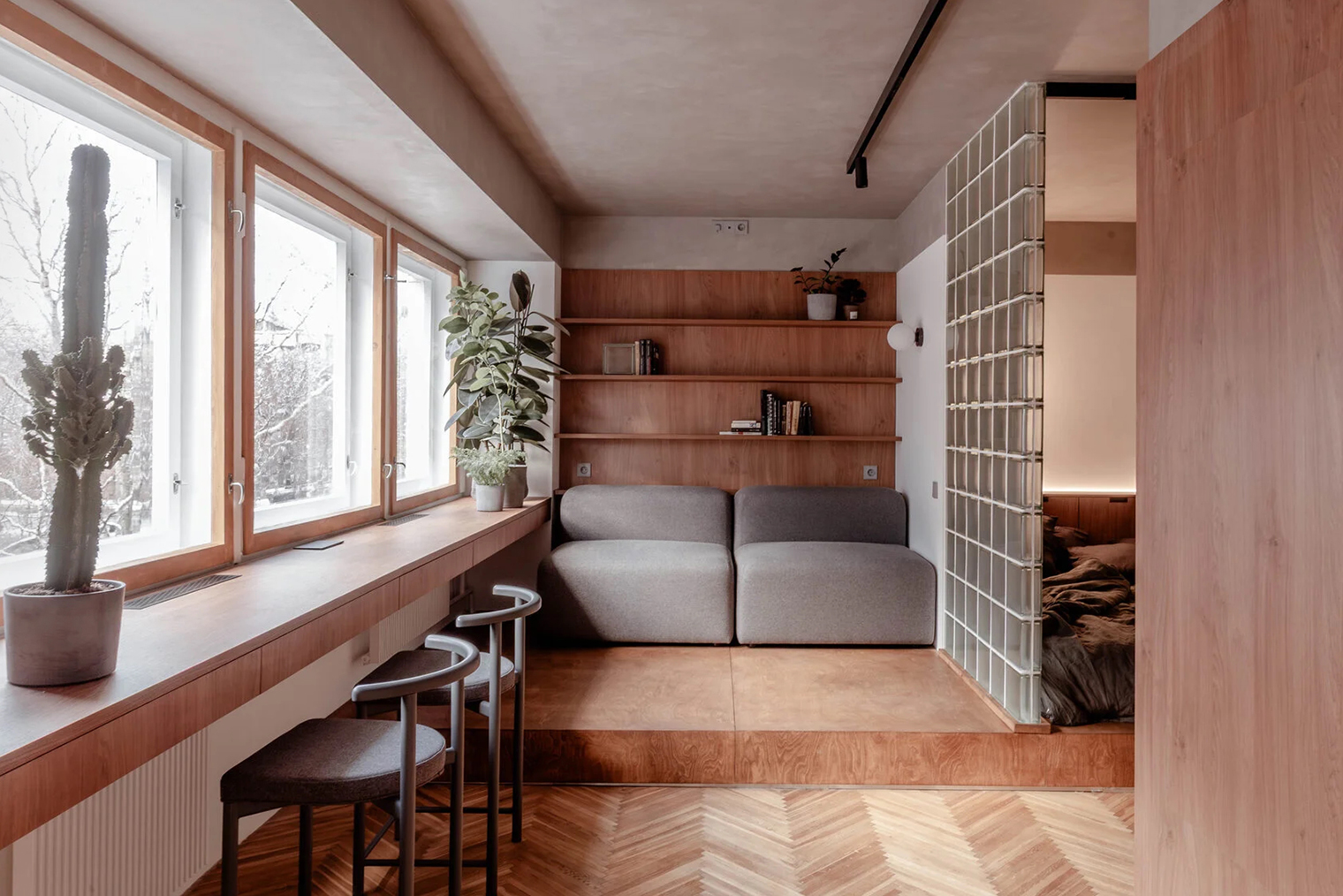 Деревянные панели в этом пространстве воплощены как функциональный элемент в виде открытых полок. Дерево дублируется на перегородке и в рабочем столе у окна. Интерьер не перегружен. © Александр Кудимов / ruetemple.ru