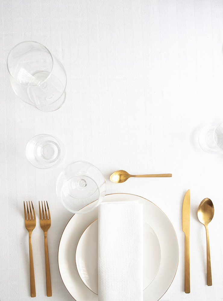 Самый простой вариант раскладки приборов для домашнего пользования. Позолоченные приборы сочетаются с золотой кромкой на посуде. Фотография: vasanty / Shutterstock