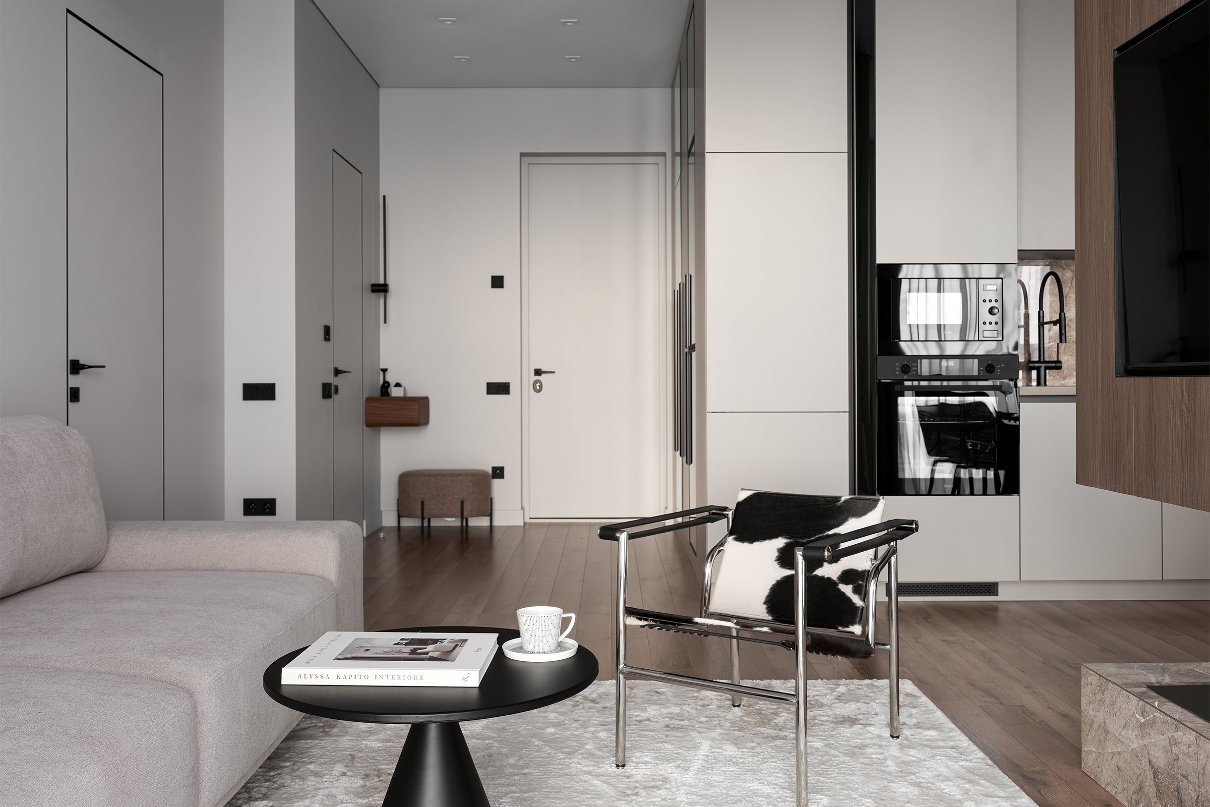 Глаз постоянно возвращается к креслу, хотя рядом стоит более темный столик, который должен быть по всем правилам визуальной доминантой. Но ему не хватает различия по форме, чтобы выделиться из других вещей. При этом за счет сочетания черного и белого в принте кресло органично вписывается в интерьер