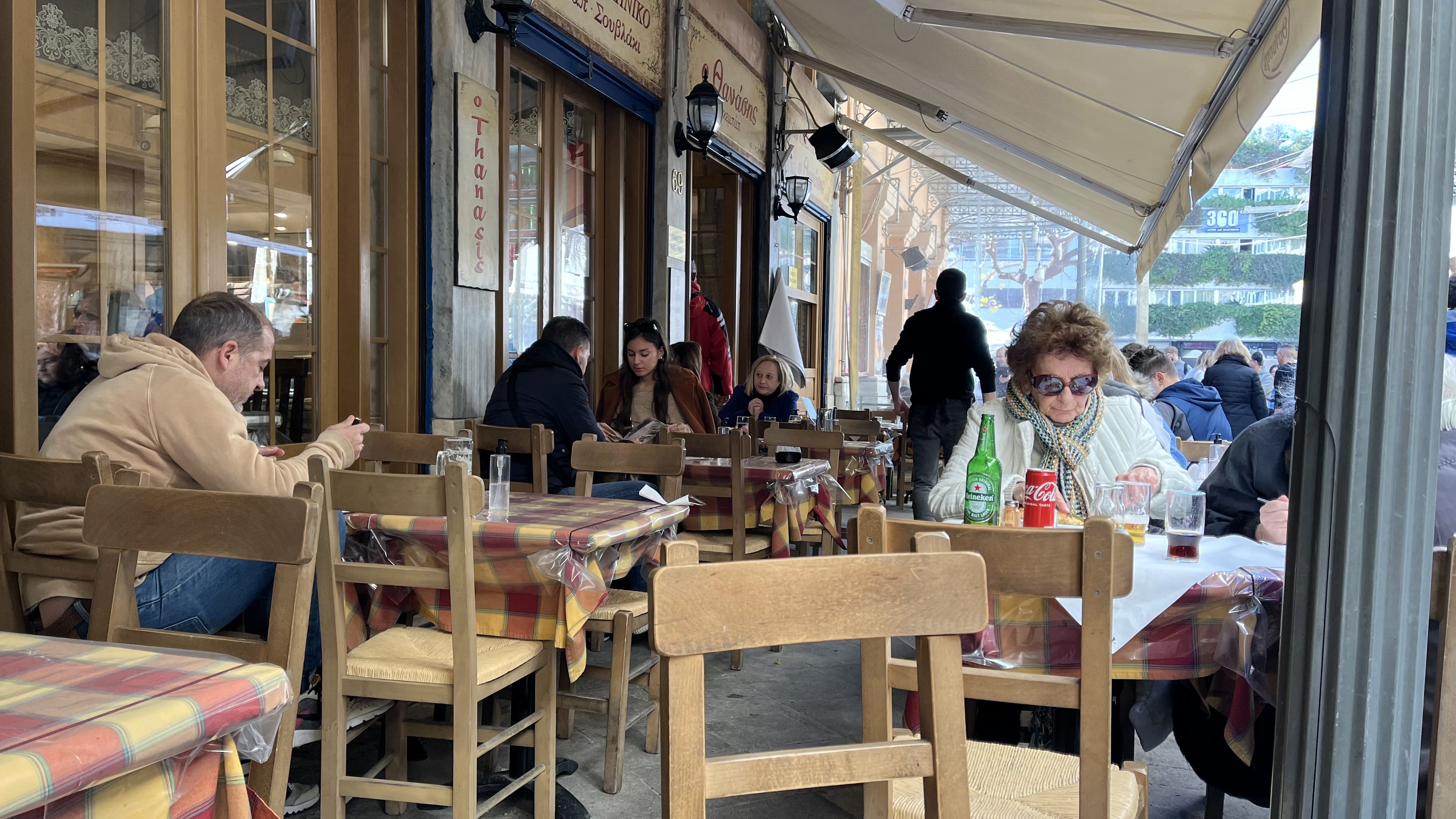 Пенсионеры на обеде в таверне на площади Монастираки. За столиком справа — компания подруг: обмениваются новостями, едят, выпивают