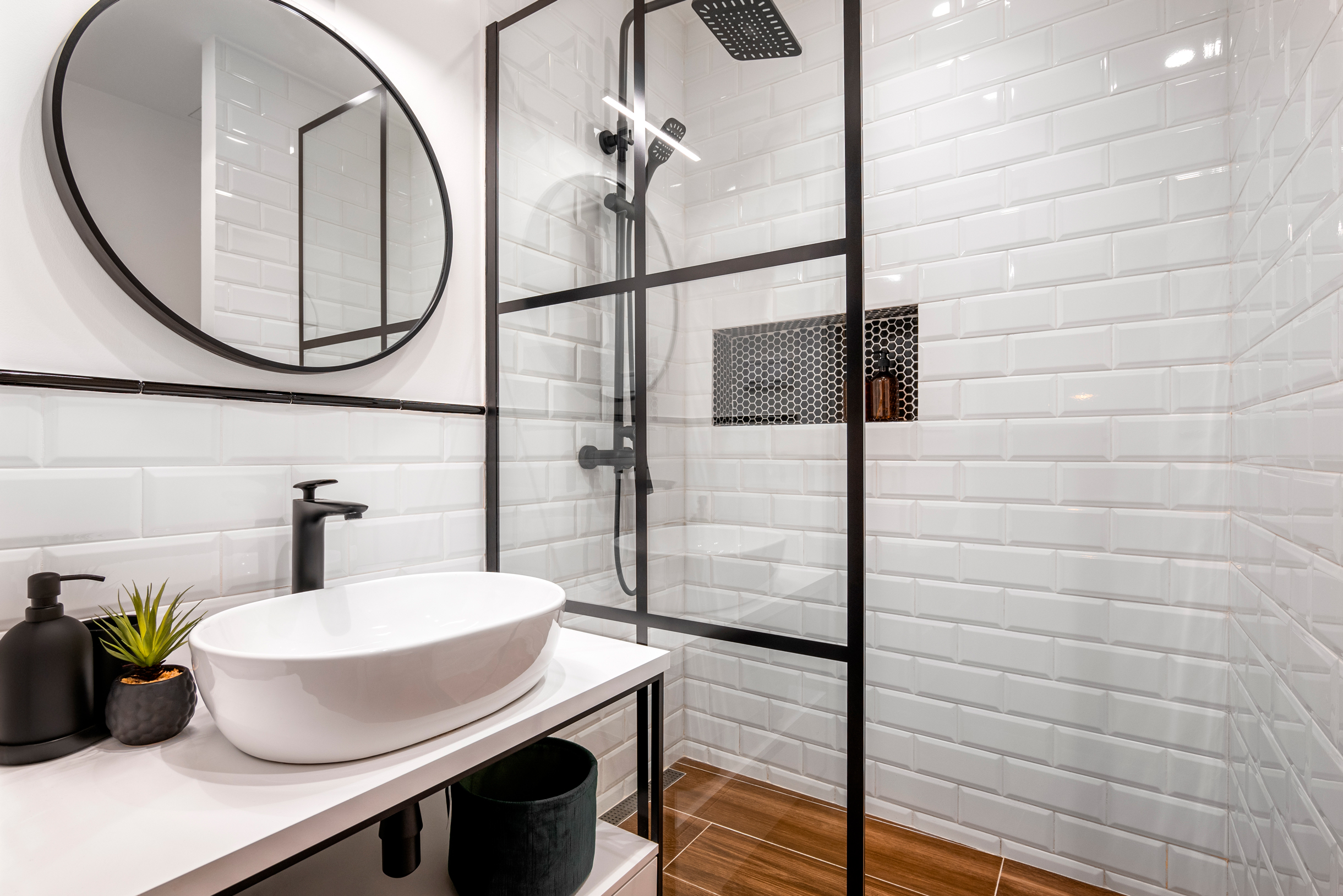 Так выглядит классическая сканди-ванная: белая плитка, черные и деревянные акценты. Фотография: Pavel Adashkevich / Shutterstock / FOTODOM