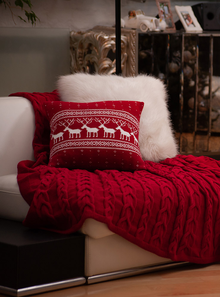 Наволочки на декоративные подушки и плед добавят новогодней атмосферы. Выбирайте классические сочетания: красный, зеленый или синий с белым или золотым. Фотография: Denys R / Shutterstock