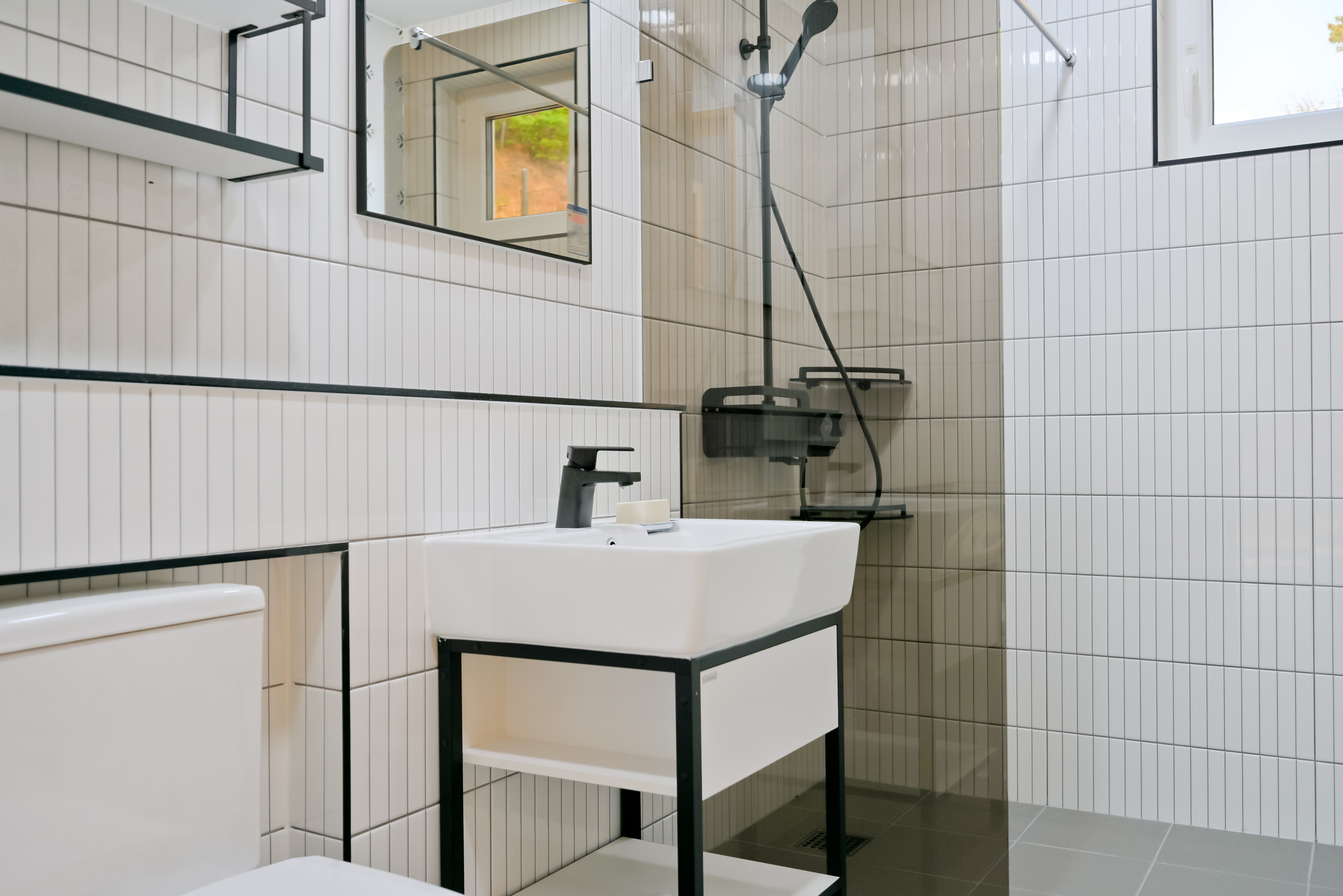 Та же узкая белая плитка, но в модной раскладке. Добавить сюда декор, и будет современная скандинавская ванная. Фотография: go daewan / Shutterstock / FOTODOM