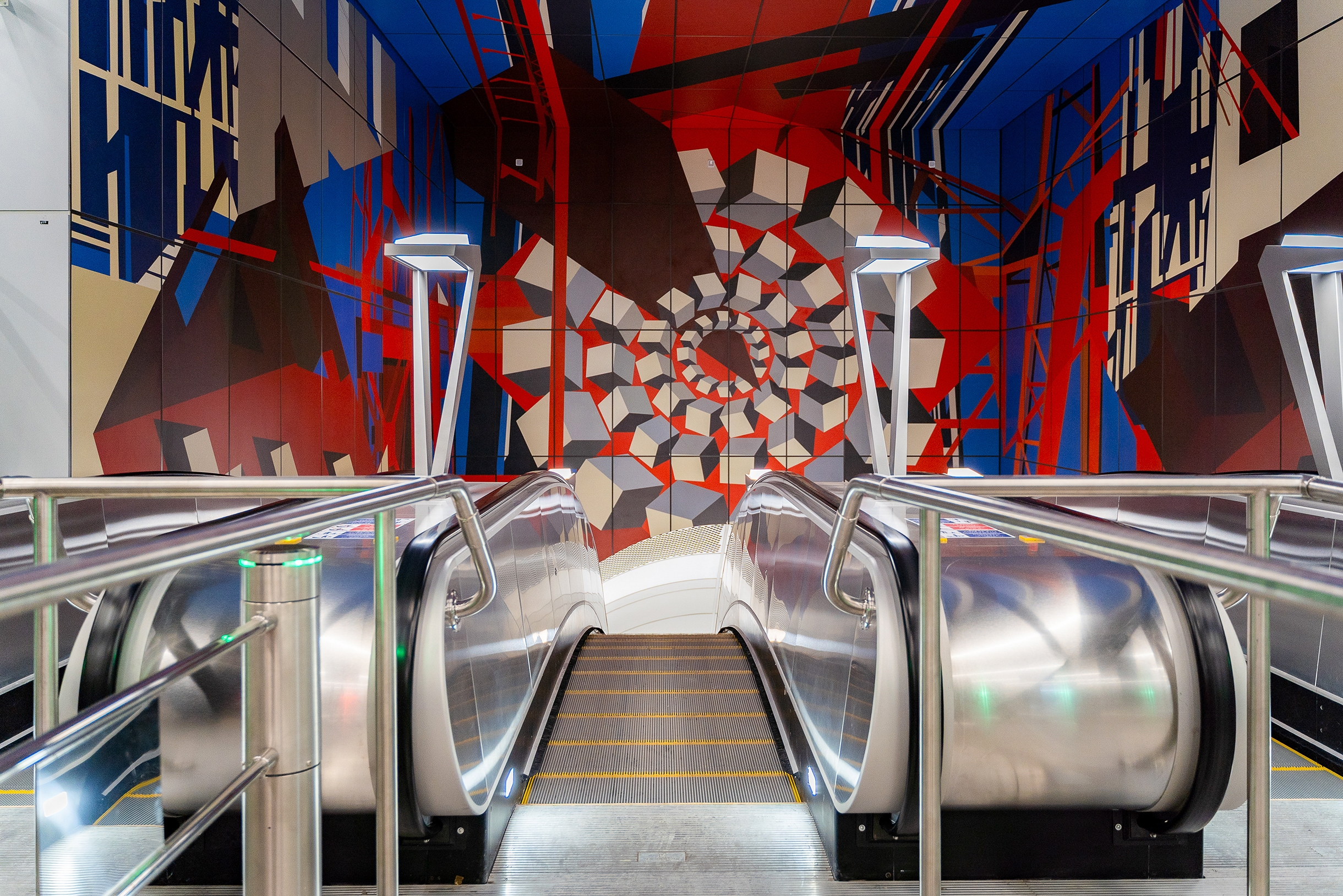 Масштабное панно над эскалаторами в абстрактной форме изображает машиностроение и литейное производство