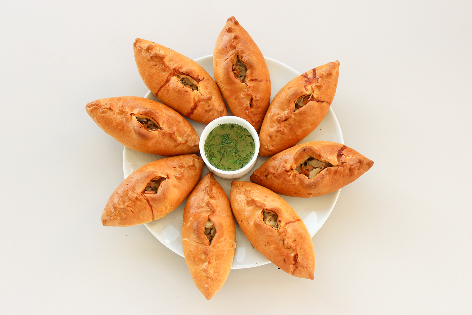 Готовые расстегаи с рыбой. Перед дегустацией бульон заливают в пирожок: так сочнее