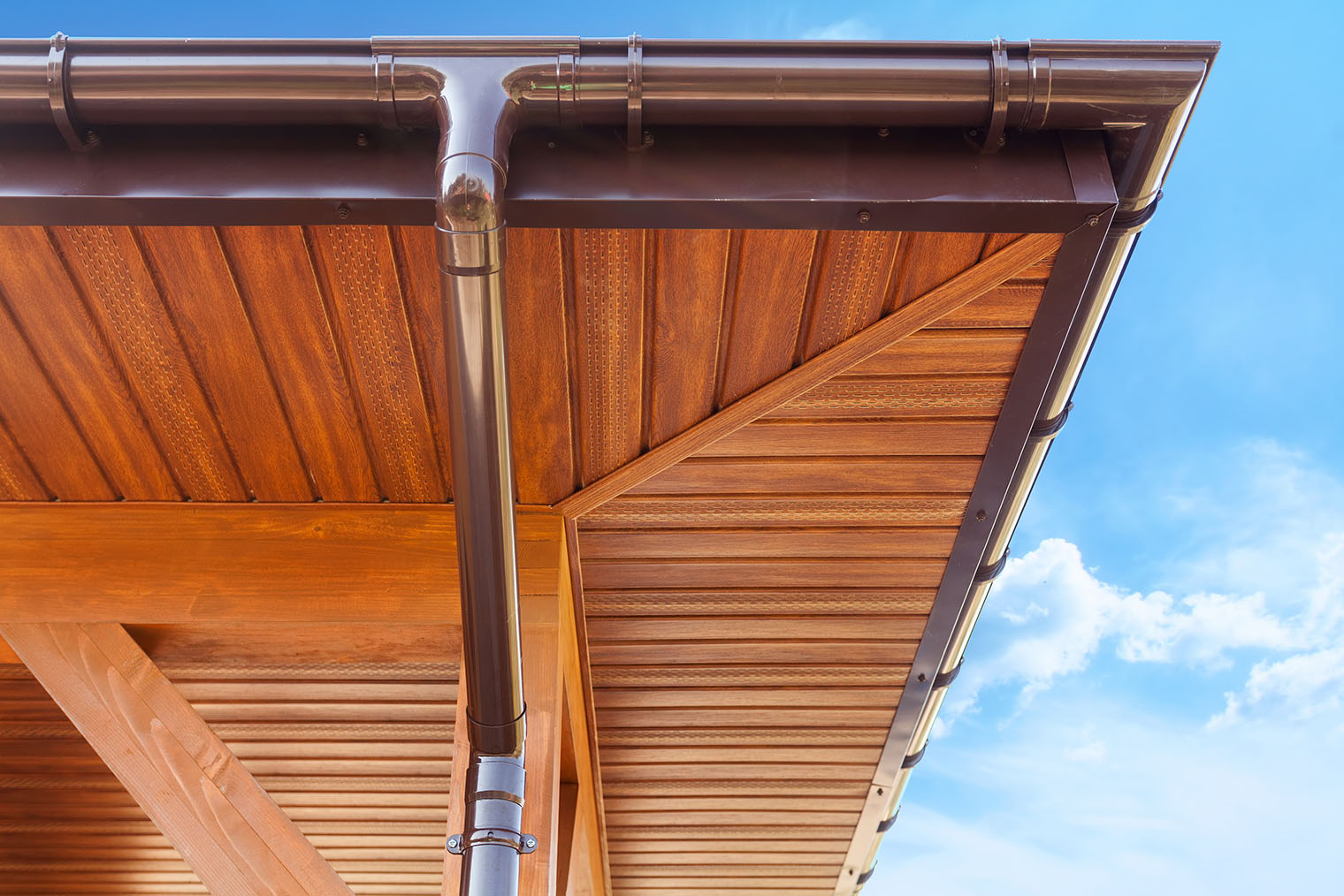 Здесь металлическим сайдингом — софитом — подшиты свесы крыши. Материал издалека не отличить от дерева. Фотография: brizmaker / Shutterstock / FOTODOM