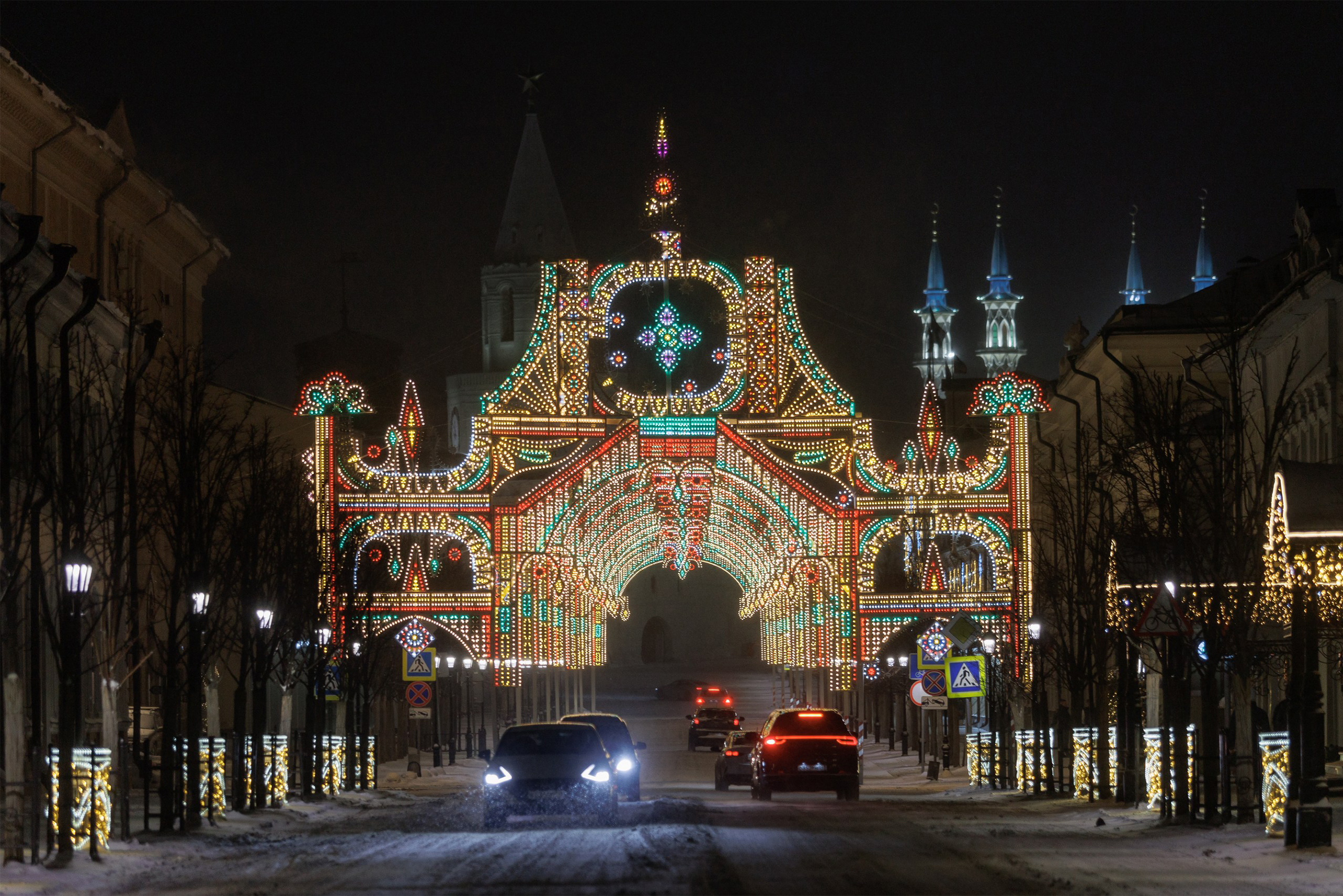 На Кремлевской улице установили светящиеся арки. Наверху можно заметить флаг Татарстана. А позади видны Спасская башня Казанского кремля и минареты мечети Кул-Шариф