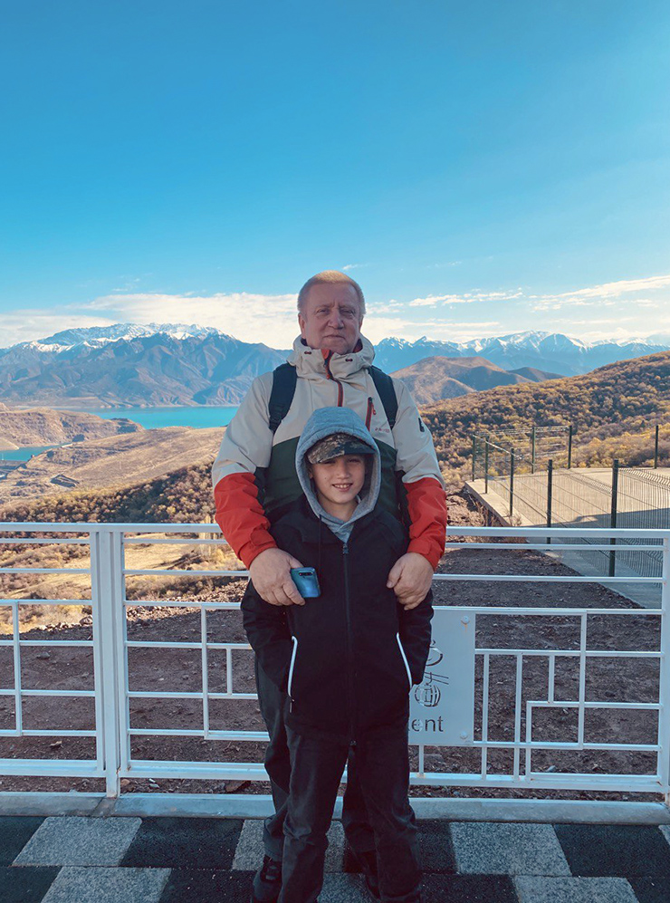 Дедушка с внуком наслаждаются видом и солнечной погодой на Чарвакском водохранилище
