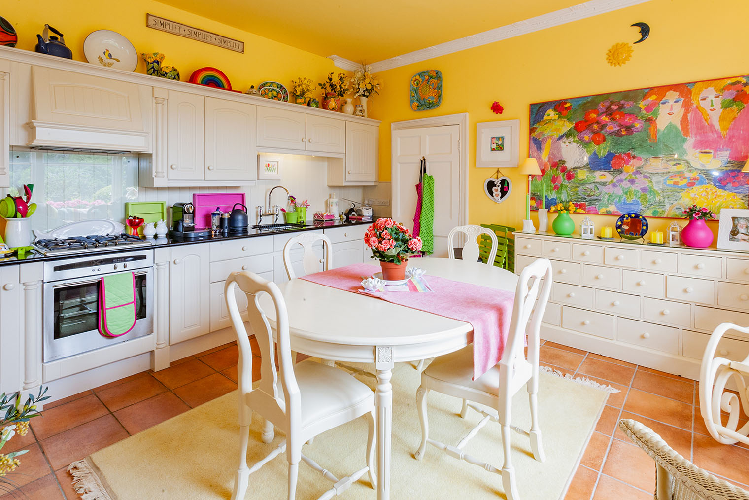 Множество ярких элементов утомляет: желтые стены, цветы, салатовые и розовые аксессуары у зеркала, на столешнице и дорожка на столе. Это рассеивает внимание. Фотография: Ian Luck / Shutterstock / FOTODOM