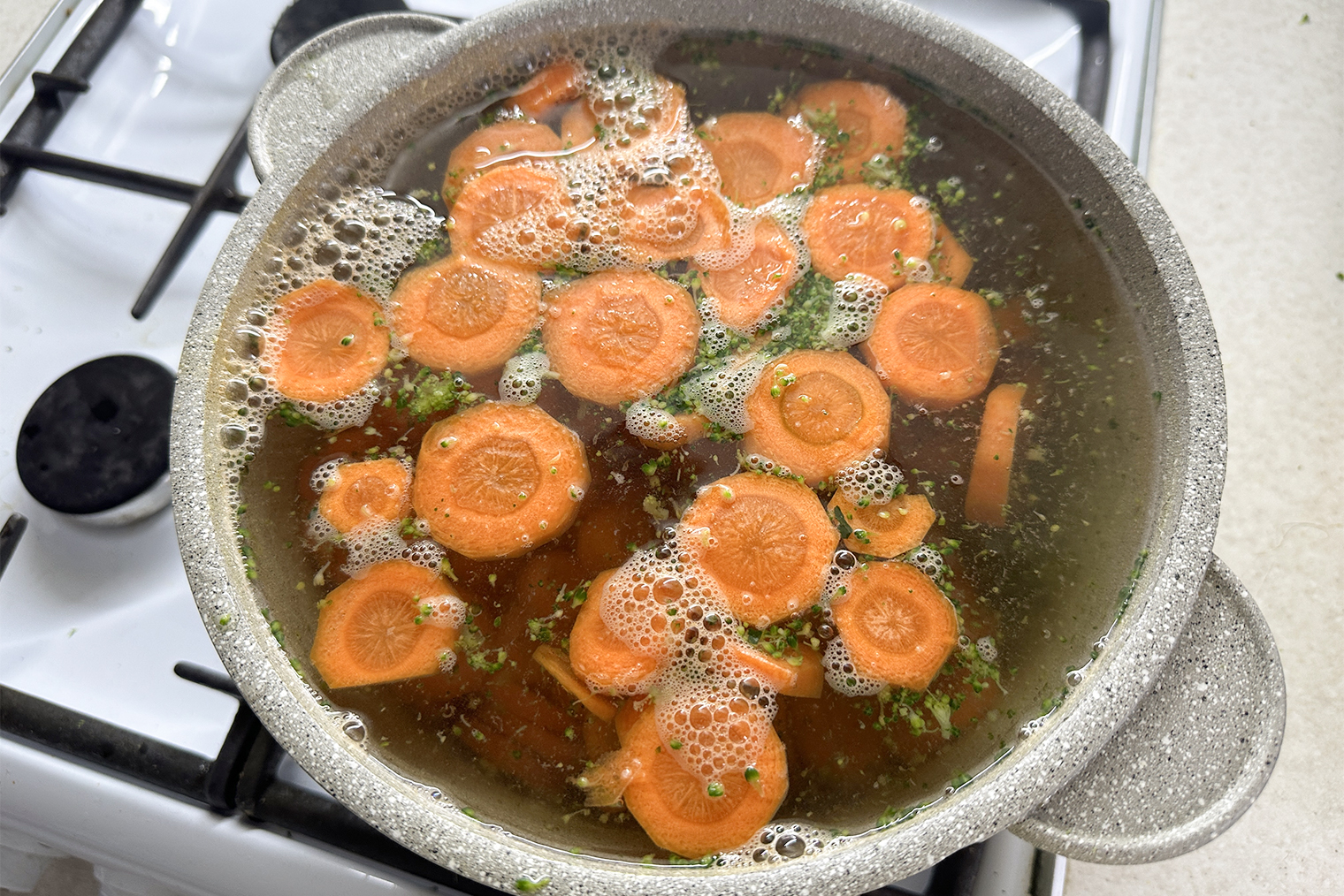 Морковь в кастрюле с оставшимися кусочками брокколи. Повар в ролике варил все овощи в одной воде