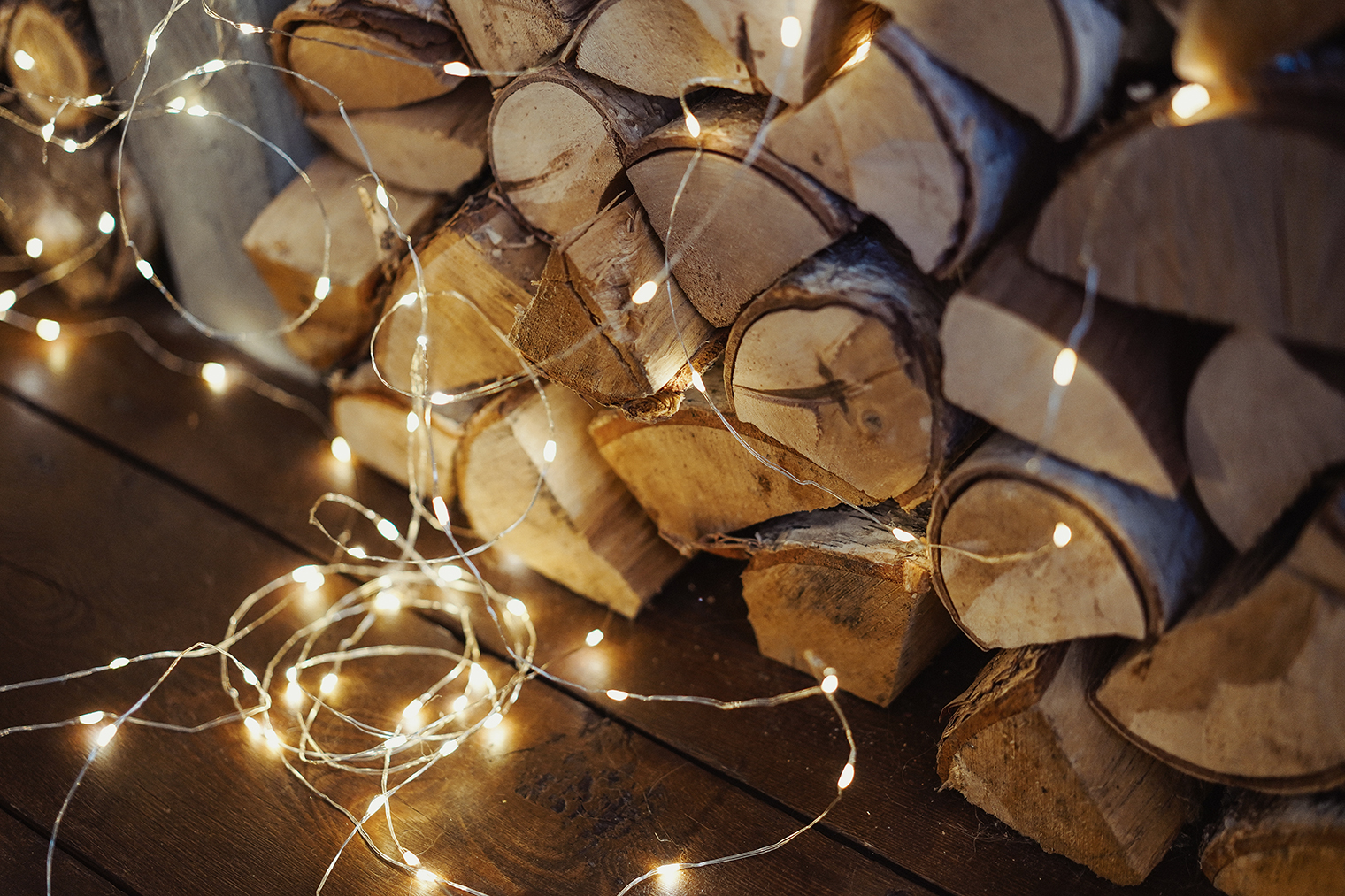 Гирляндой «Роса» можно подсветить отдельные элементы декора, например стопку дров, расположенных под навесом. Фотография: Vesta Gordes / Shutterstock