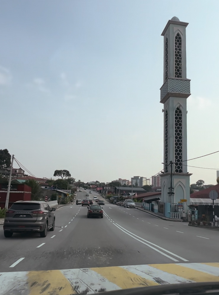 Типичная улица в Джохор⁠-⁠Бару: вокруг низкоэтажная застройка и виднеется мечеть