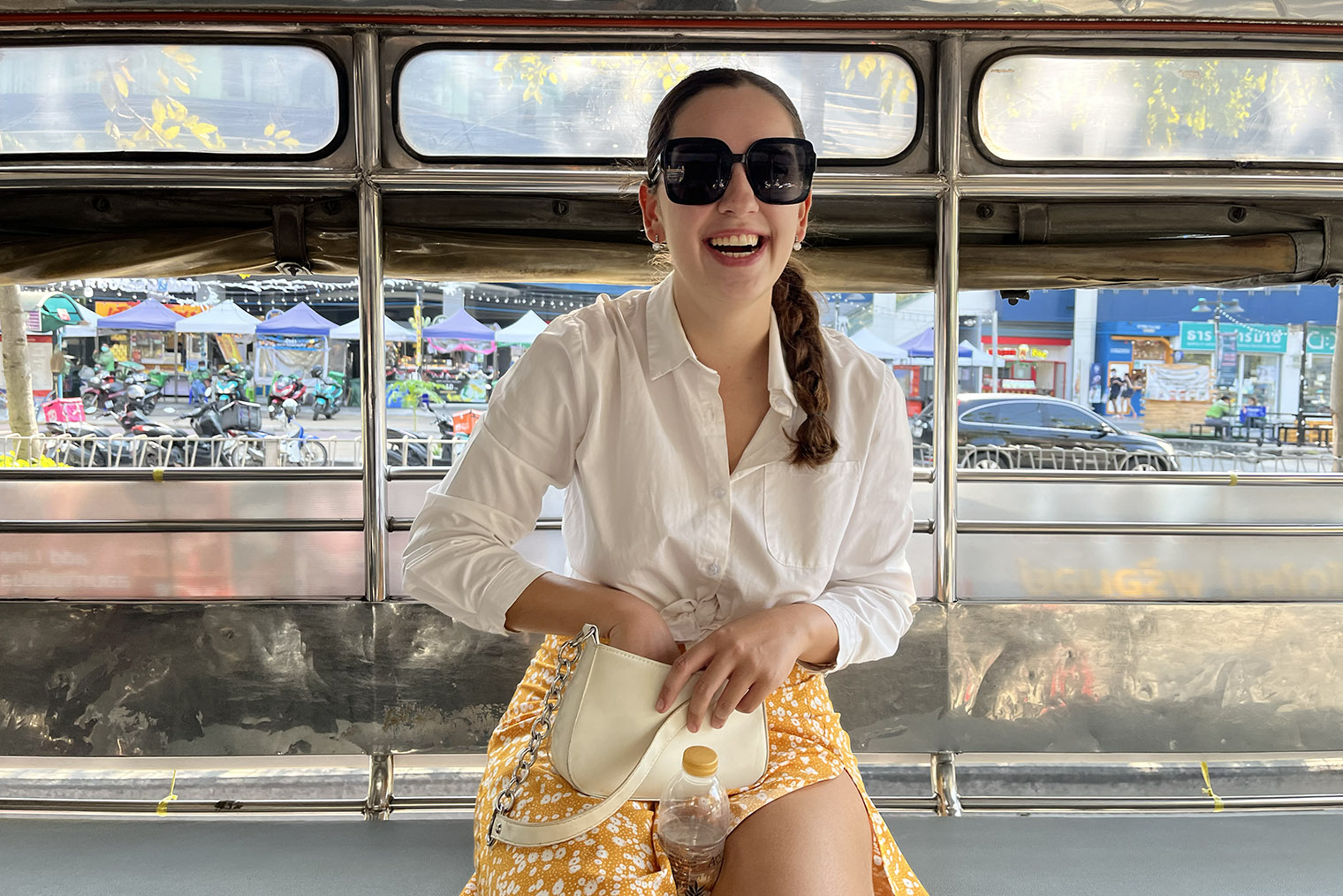 Это я в тук-туке — так называют маленький автобус на базе мотороллера. Позади меня — местный рынок