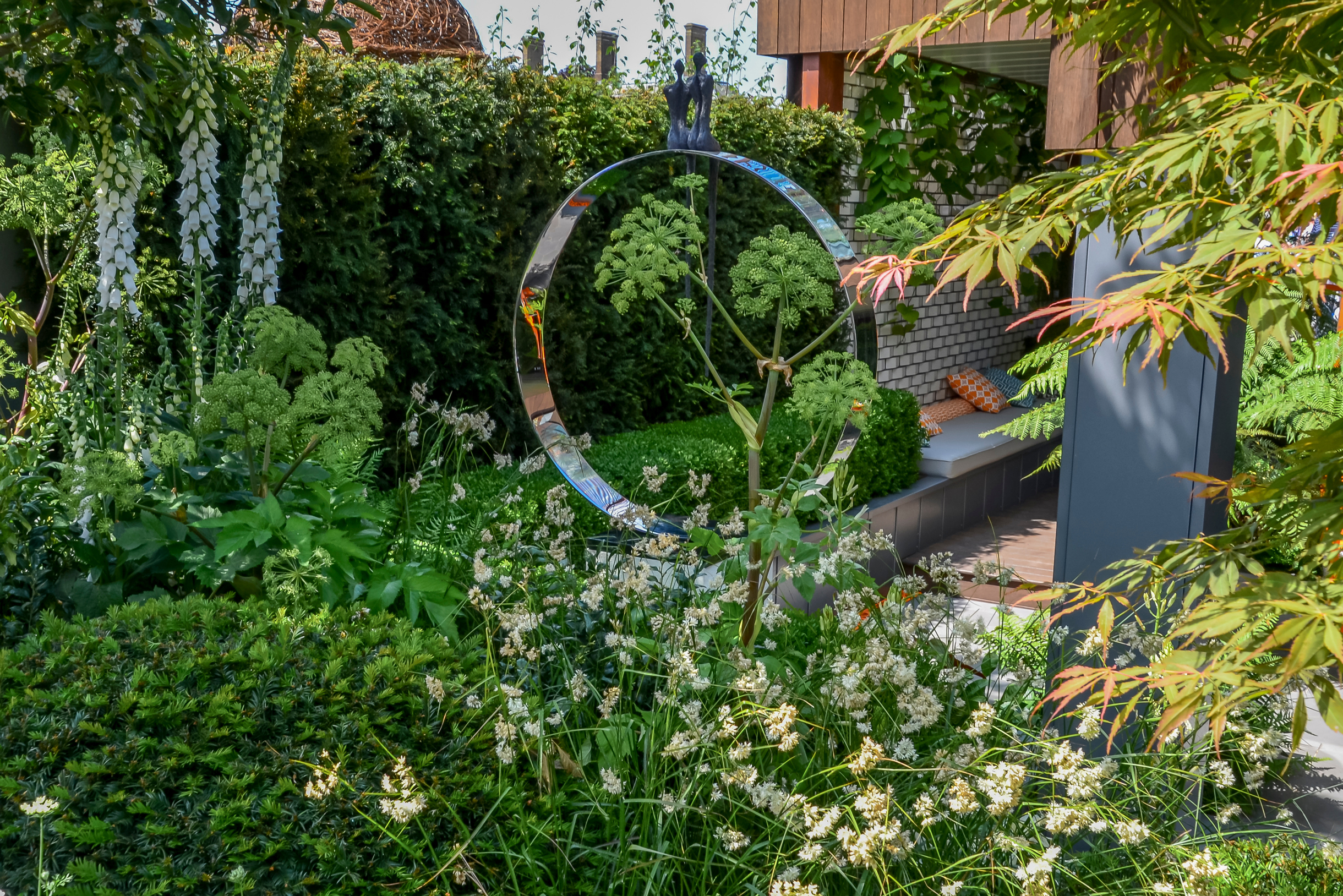 Сад в природном стиле — это не только деревяшки, камешки и всякое старье. Вот кто⁠-⁠то решил поставить в саду зеркальное кольцо. Прелесть этого стиля в том, что он прекрасно сочетается с любой архитектурой. Фотография: LapaiIrKrapai / Shutterstock / FOTODOM