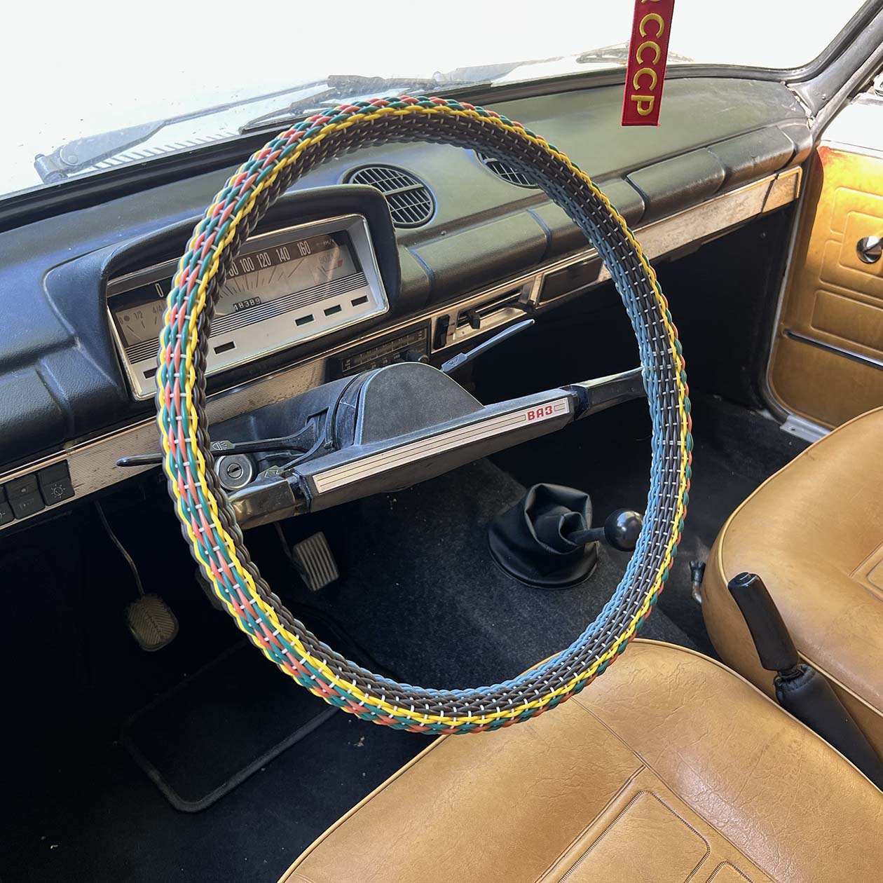 Оплетка руля абсолютно новая, я нашел ее на «Авито». За рулем — новая пепельница, а слева от нее — советский приемник