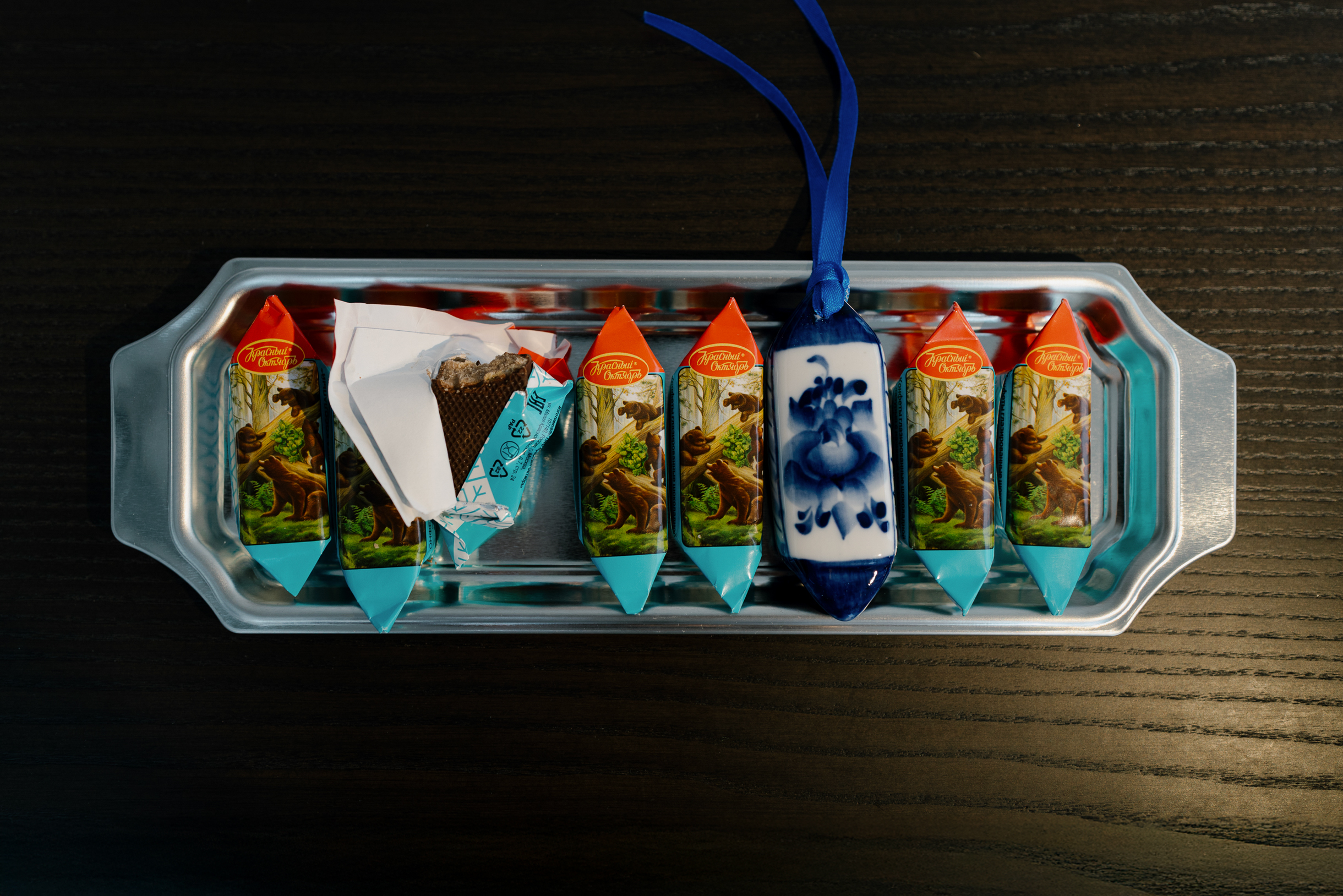 Интересные елочные игрушки можно добавить в композицию на стол для атмосферы. Главное — не ошибиться конфетой