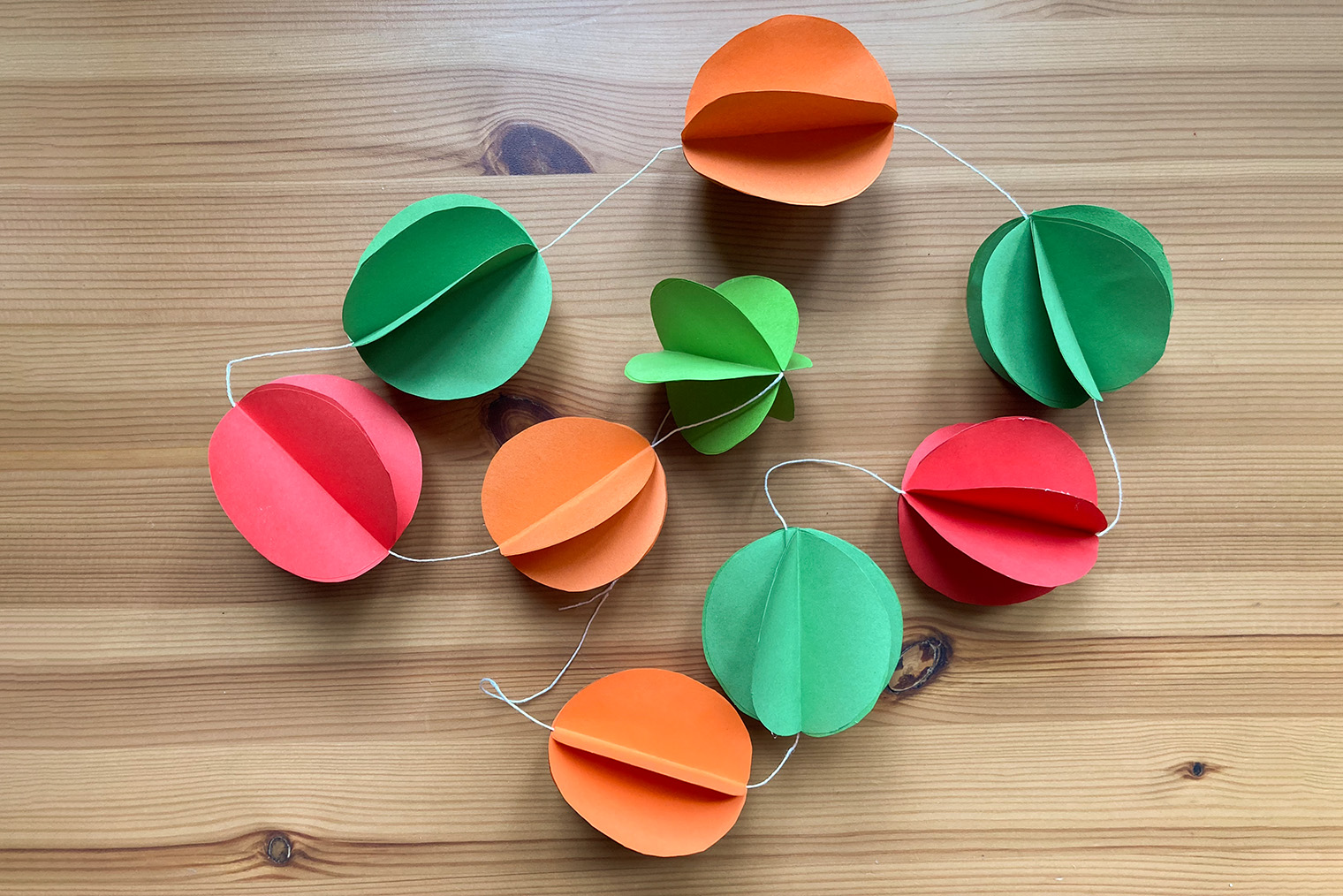 Чтобы гирлянда выглядела интереснее, можно сделать ее из оберточной или блестящей бумаги