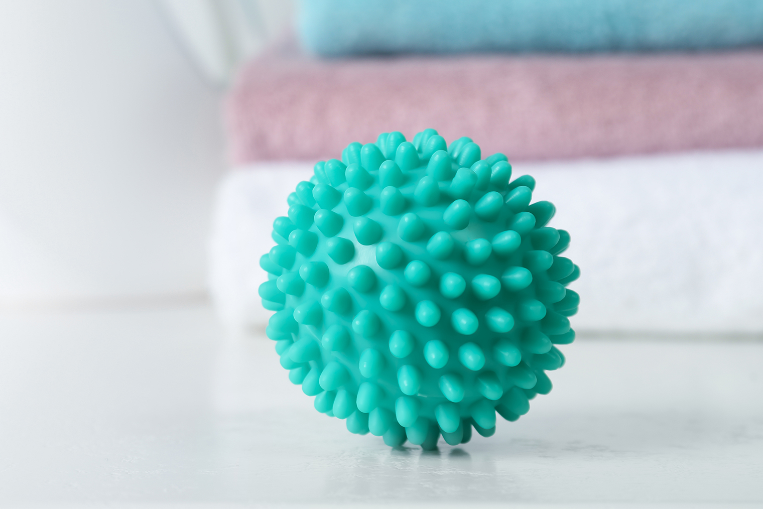 Мячики, у которых ничего внутри нет, — не лучший выбор. Вода заливается внутрь, при стирке они становятся тяжелыми, появляется плесень и неприятный запах. Лучше покупать шарики с отверстиями, чтобы вода свободно вытекала, или из цельного куска резины. Фотография: New Africa / Shutterstock / FOTODOM