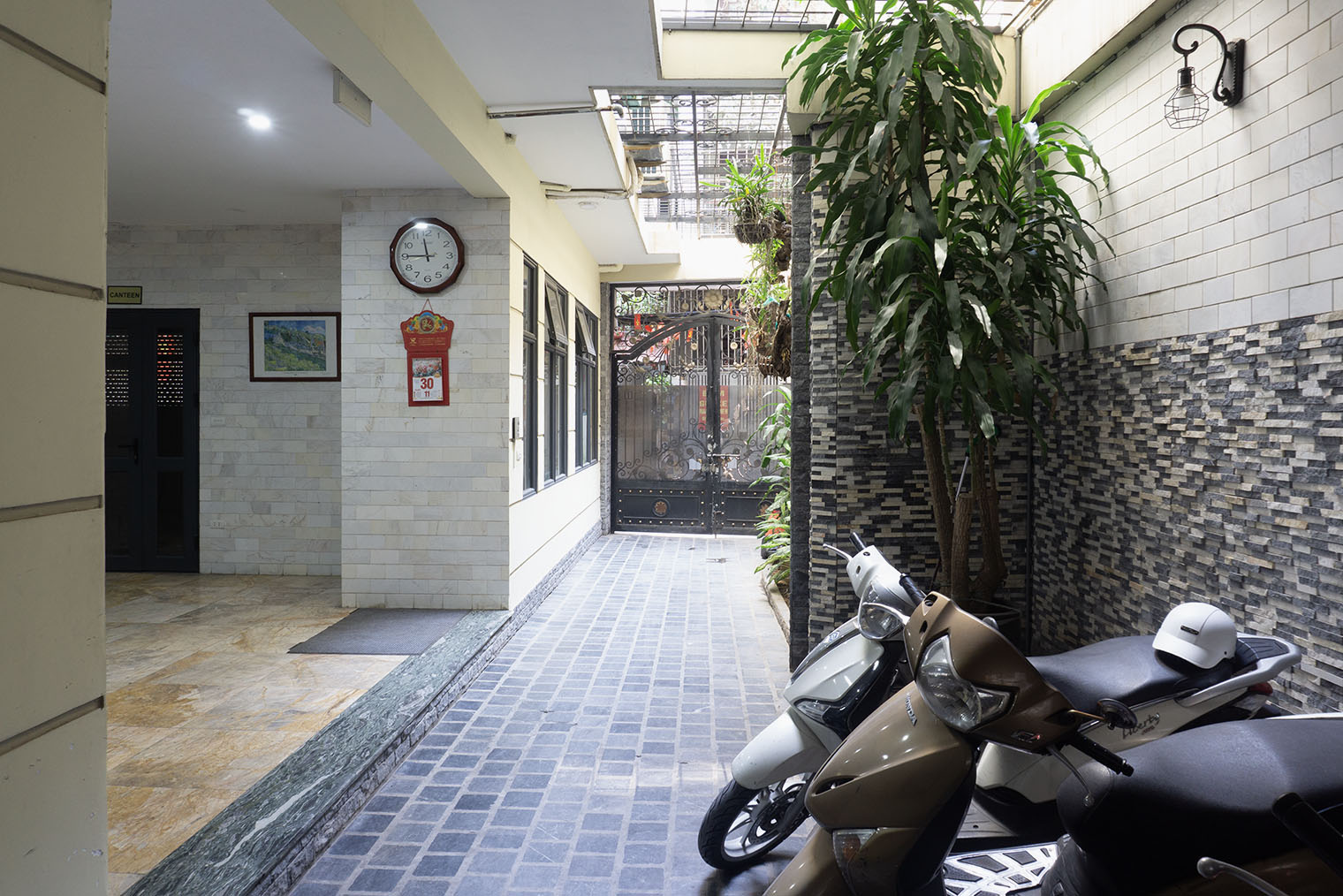 Выезд с парковки на небольшую улочку, украшенную флагами. Надо открыть железные ворота, а потом уже выгонять байк. Закрыть ворота обычно помогали тетушки из дома напротив