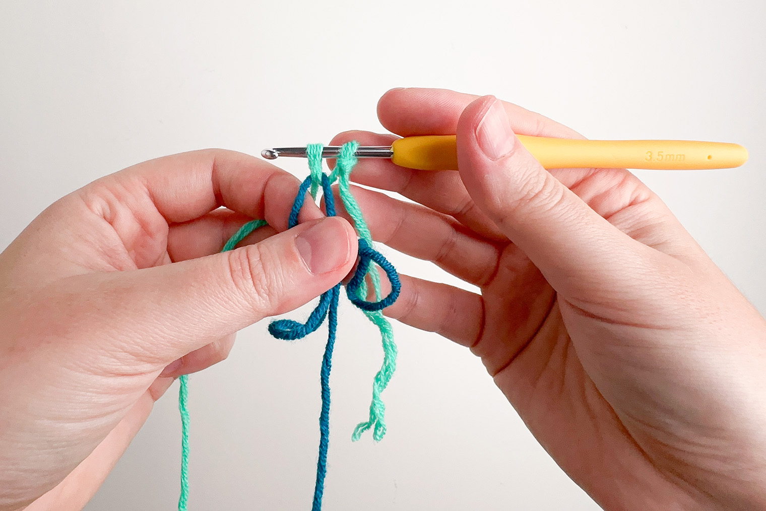 Ряд 1. Присоединяю нить второго цвета к кольцу амигуруми. На фото вытянула из-под кольца основную нить второго цвета и сформировала петлю. На крючке получилось две петли — дальше через них провязываем 1 СБН как обычно