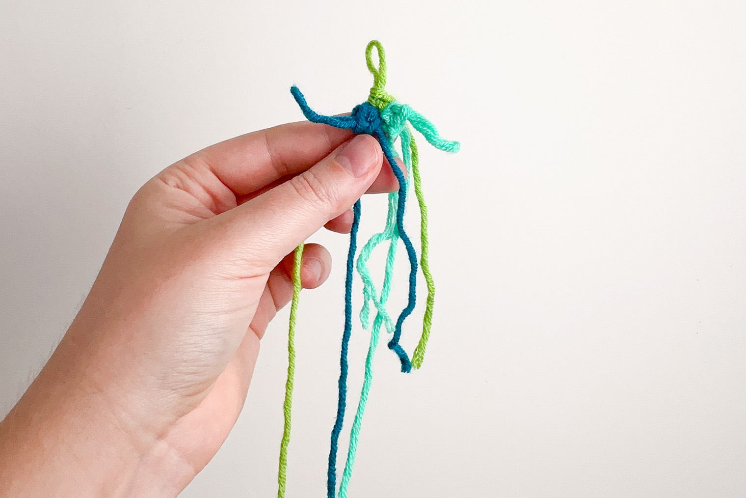 Ряд 1. Вязание после того, как затянули кольцо амигуруми. Рабочие петли каждого цвета оставляем вытянутыми на протяжении всего вязания