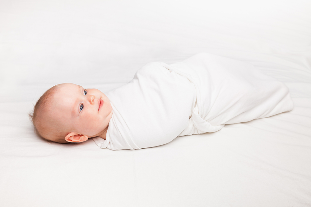 Как правильно укладывать младенца спать. Ребенок спит только в пеленке, без одежды и одеяла. Фото: Dmitry Naumov / Shutterstock