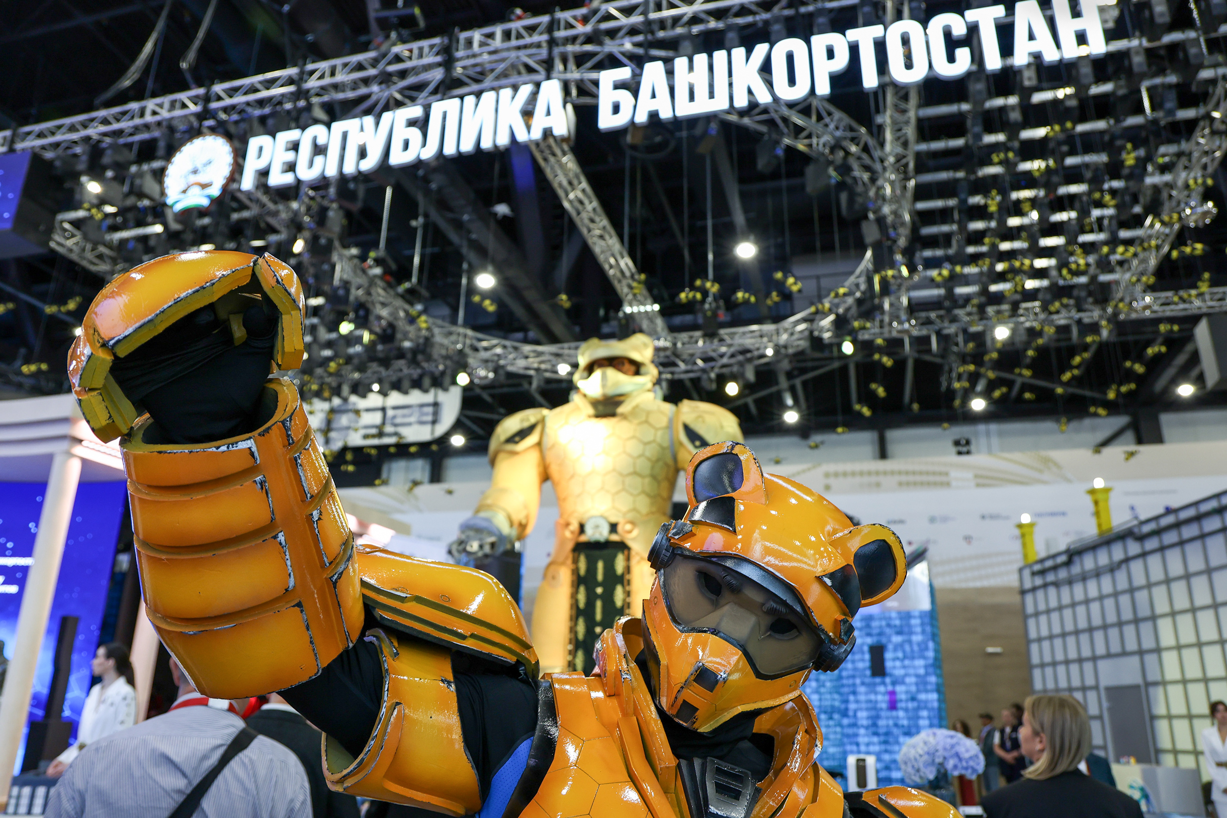 На заднем плане — кибермедведь-пасечник высотой 6,5 метра в медовой броне на стенде Башкортостана. На переднем — медведь-химик завода «Росхим». Фотография: Артем Пряхин / Фонд Росконгресс