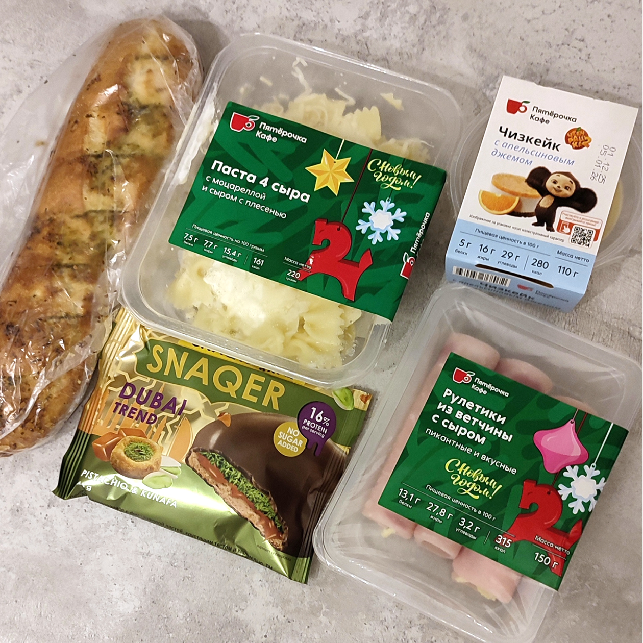 Давно не брала готовую еду не в доставке. Все кажется очень аппетитным — либо я очень голодная. Набираю макароны, рулетики, чизкейк с апельсином, прихватываю багет с чесноком и любимую печеньку