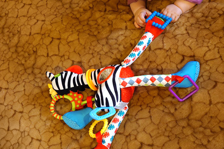 Ребенок огромный молодец: лежа на животе и поддерживая себя руками, взял игрушку