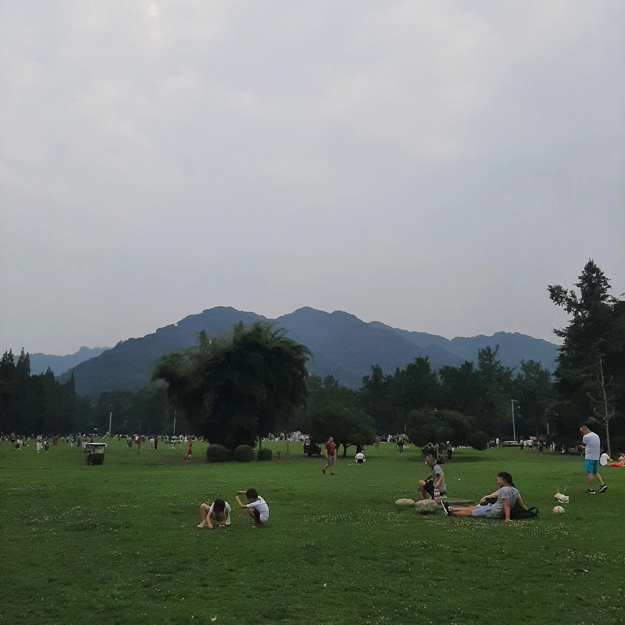 Так местные охлаждаются в пасмурный день — лежат на травке у подножия горы Цинчэн